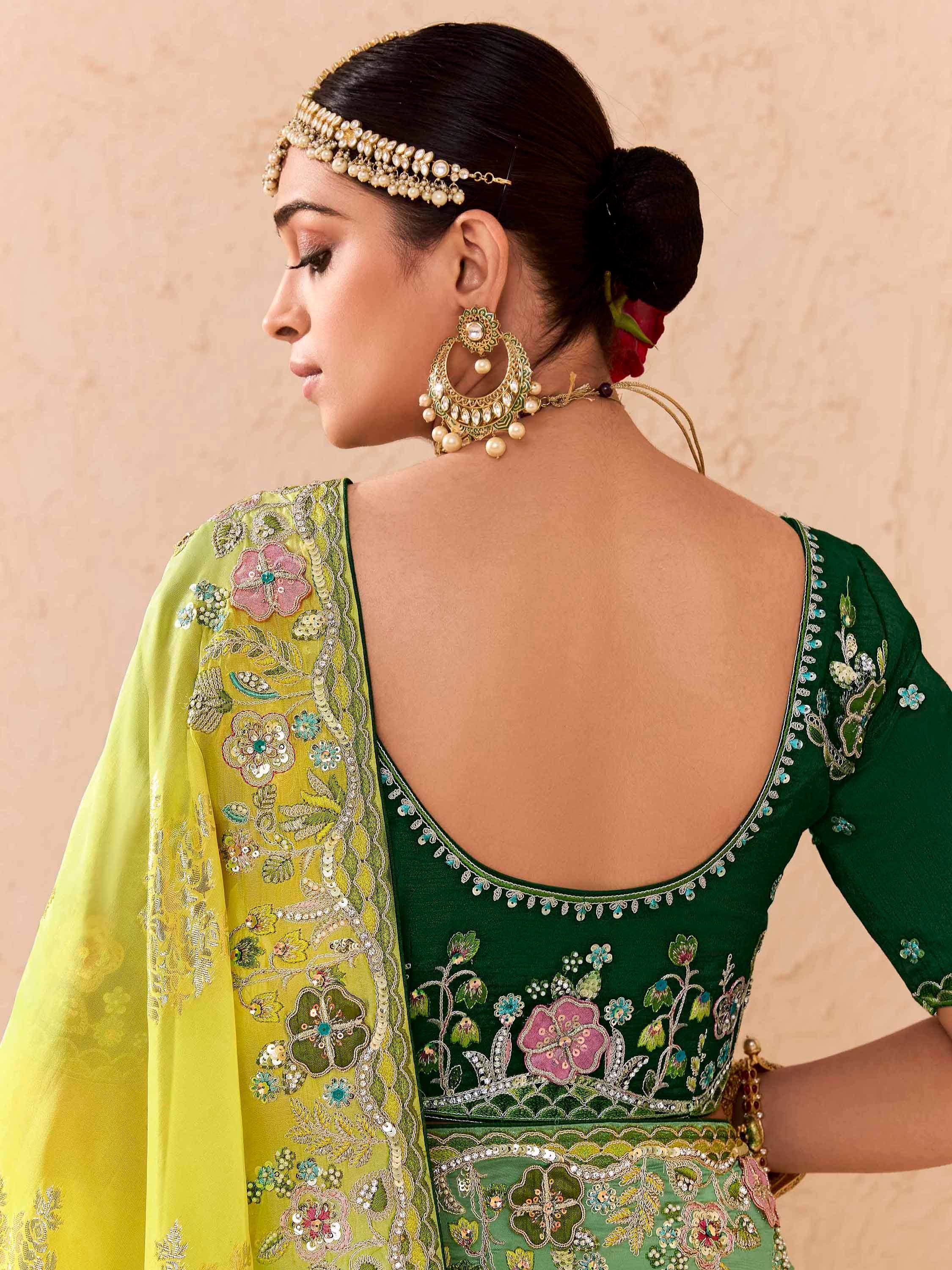 Green embroidered lehenga choli with floral motifs, pearl jewelry, and open back design