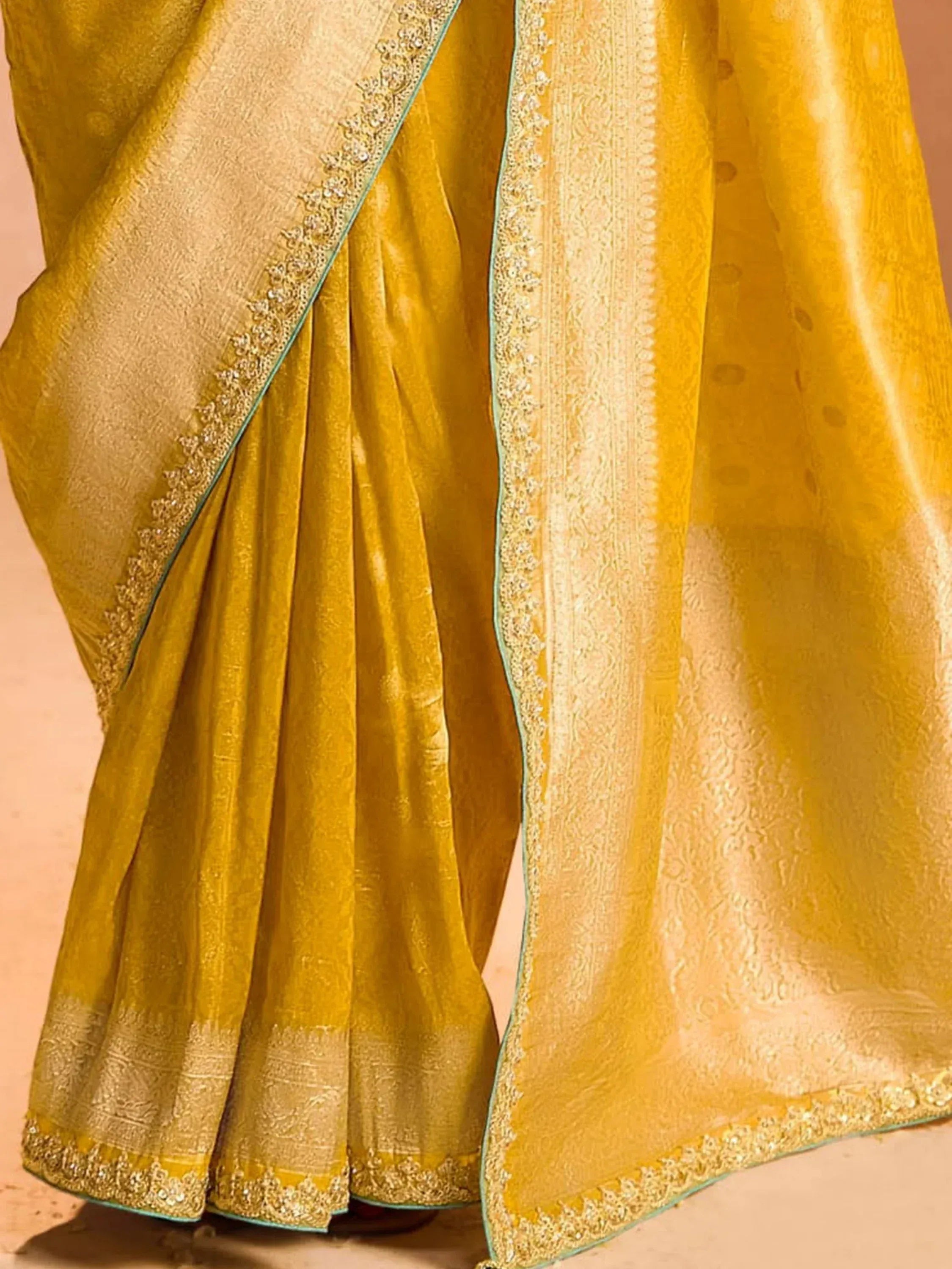 Golden yellow saree with intricate embroidery and zari border, ideal for Indian ethnic wear occasions.