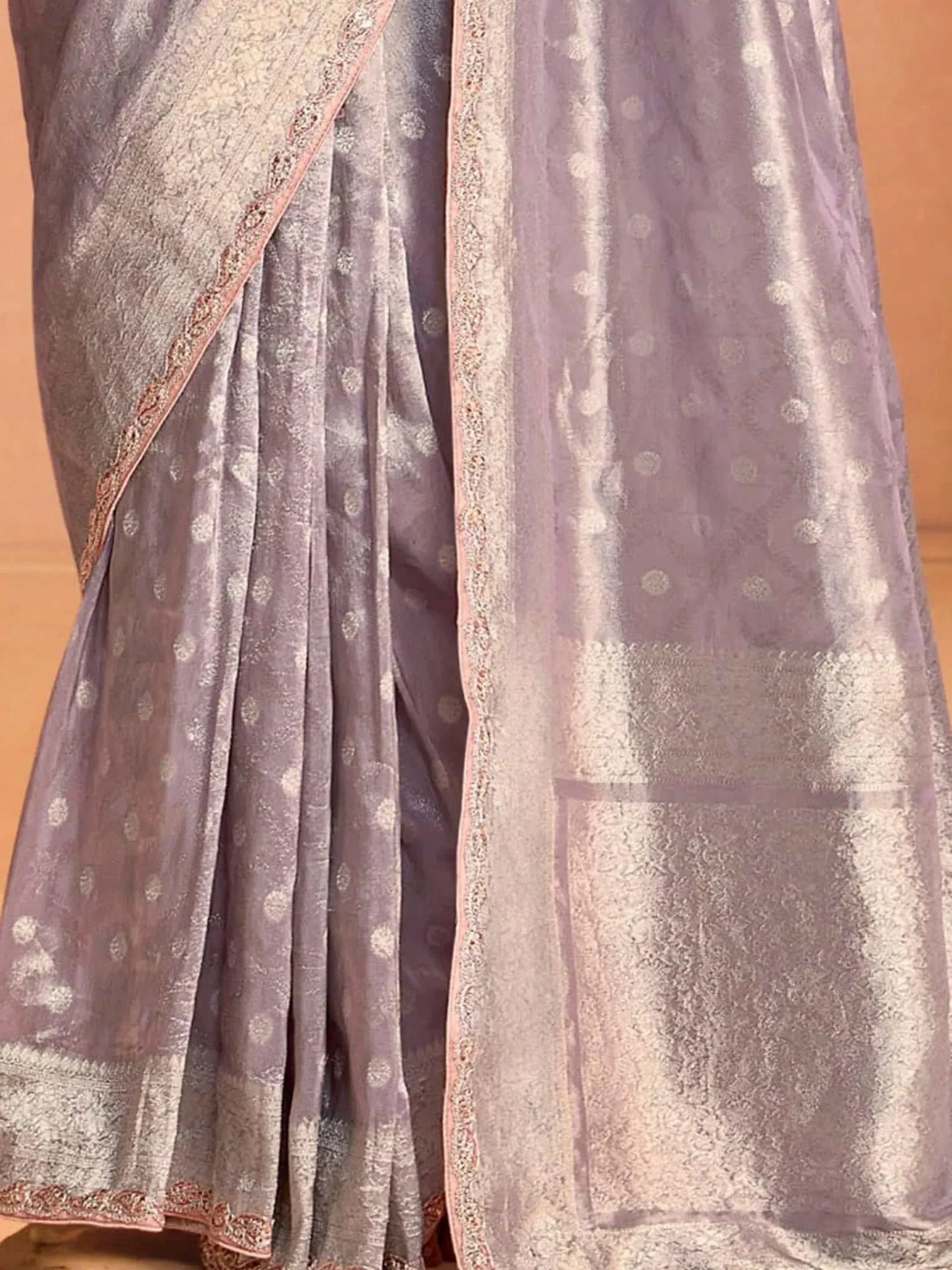 Lavender ethnic gown with silver floral print and embroidered border, perfect for Indian occasions.