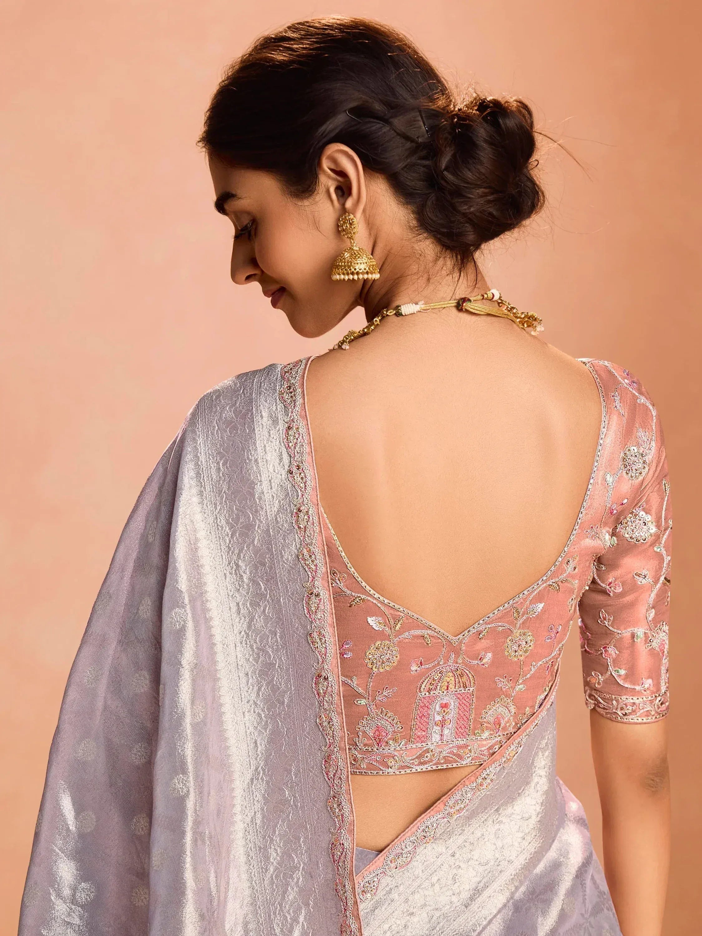 Pink embroidered backless blouse with silver saree, gold jhumka earrings, traditional Indian ethnic wear