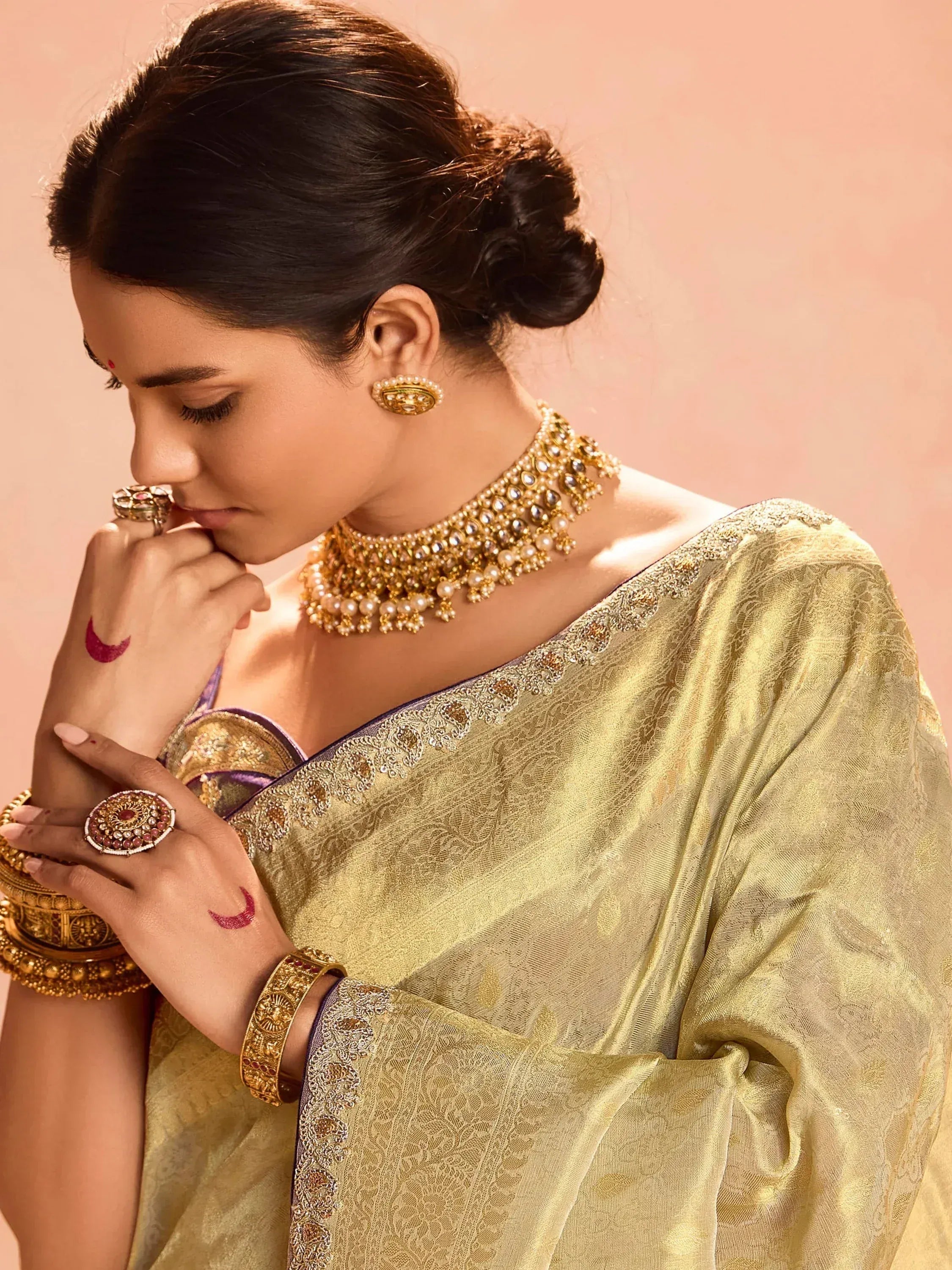 Elegant woman in golden saree with intricate jewelry, traditional Indian ethnic wear