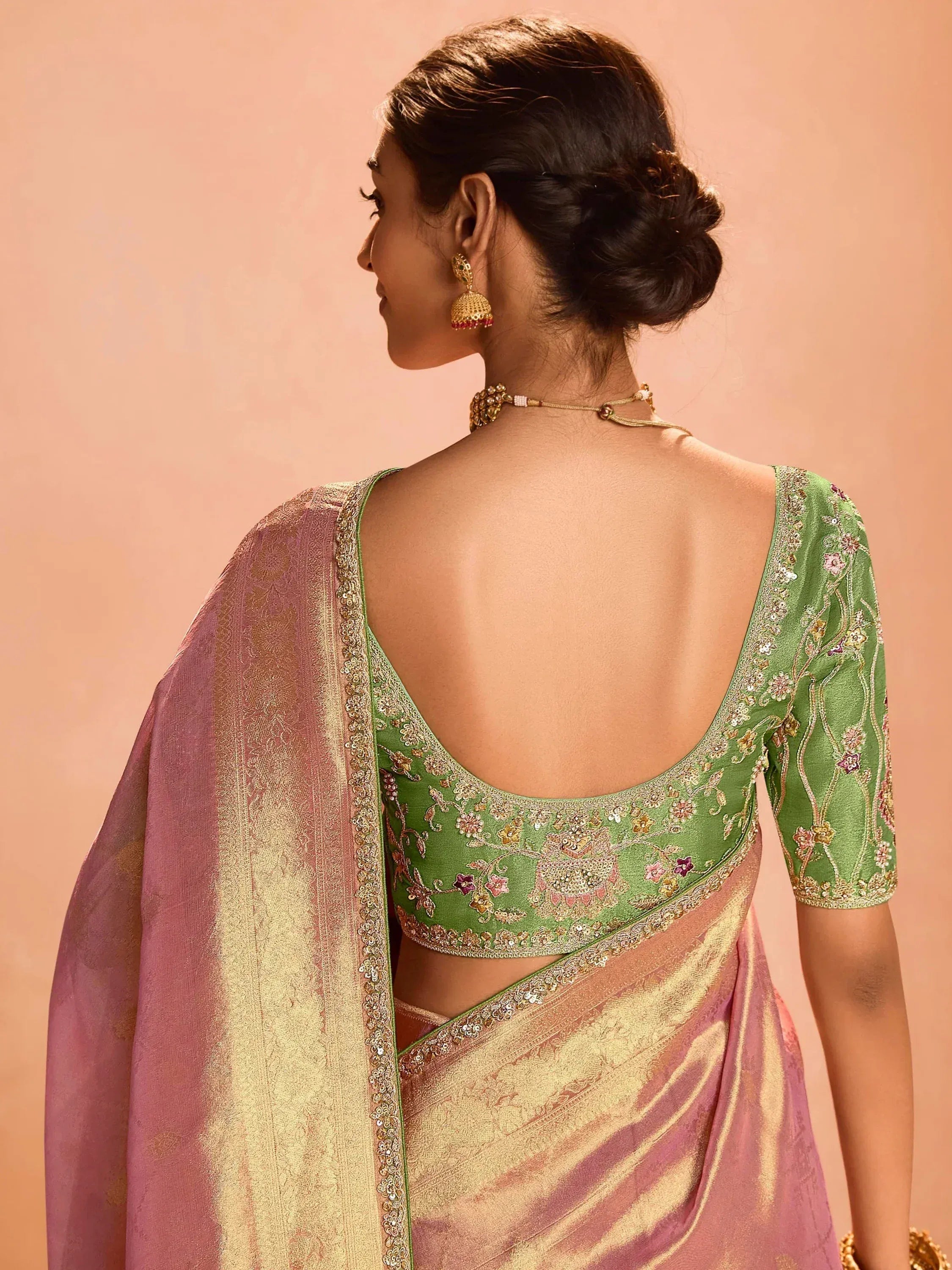 Green embroidered blouse with pink saree, showcasing elegant Indian ethnic wear design