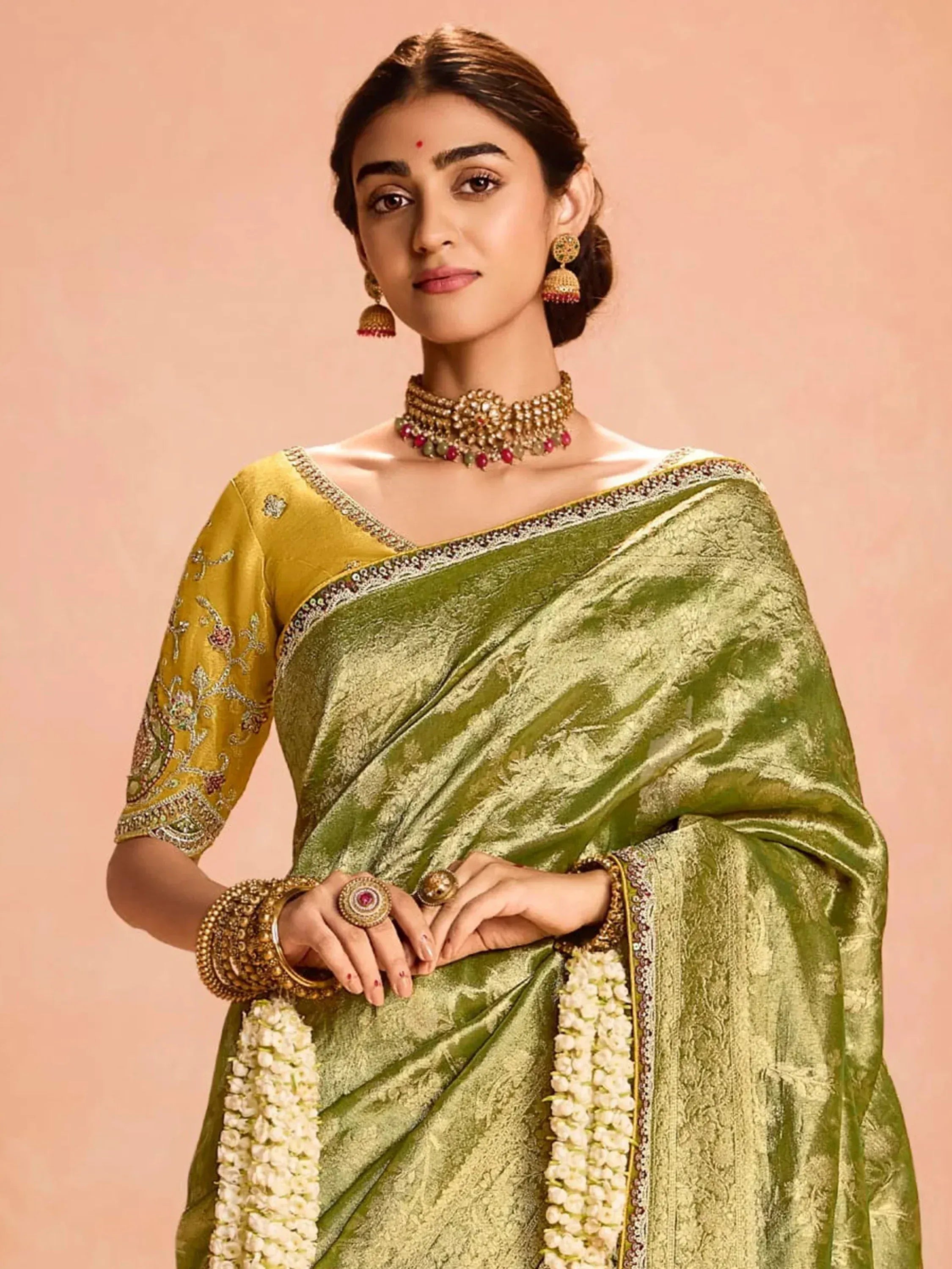 Elegant green silk saree with golden embroidery and traditional jewelry for Indian ethnic wear