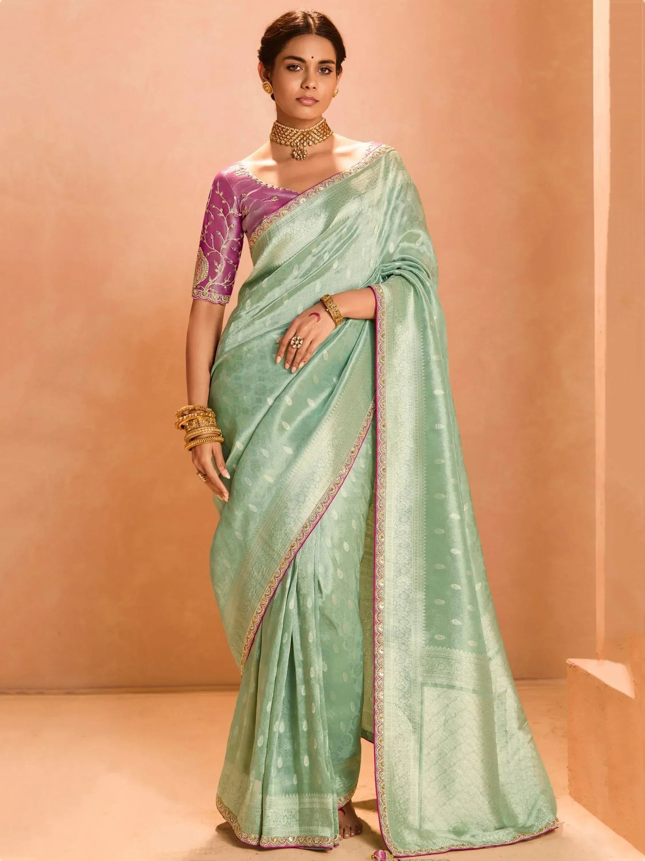 Mint green saree with purple blouse, gold embroidery, and traditional jewelry for Indian ethnic wear