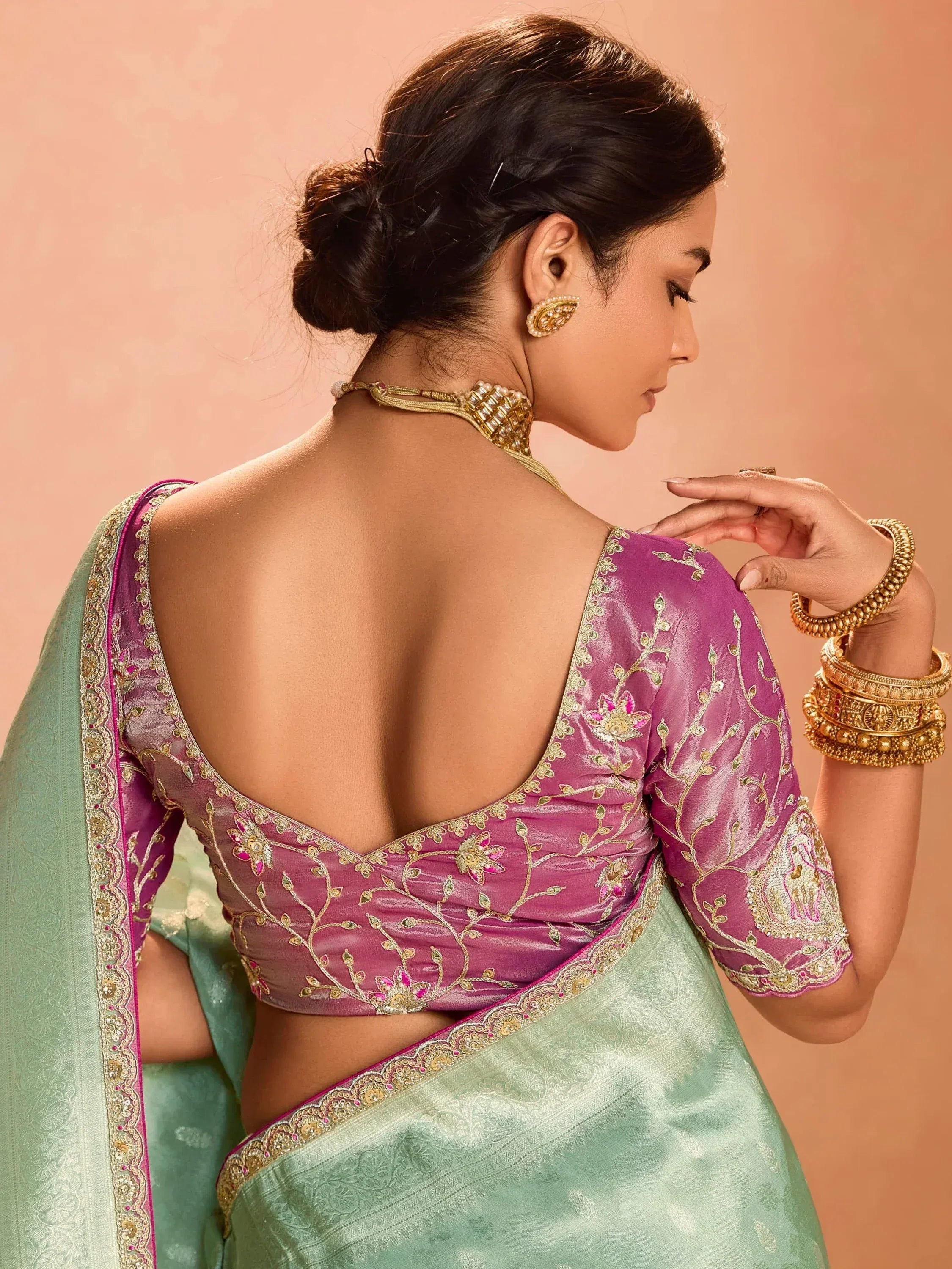 Elegant purple embroidered blouse with backless design paired with mint green saree, perfect for Indian ethnic wear.