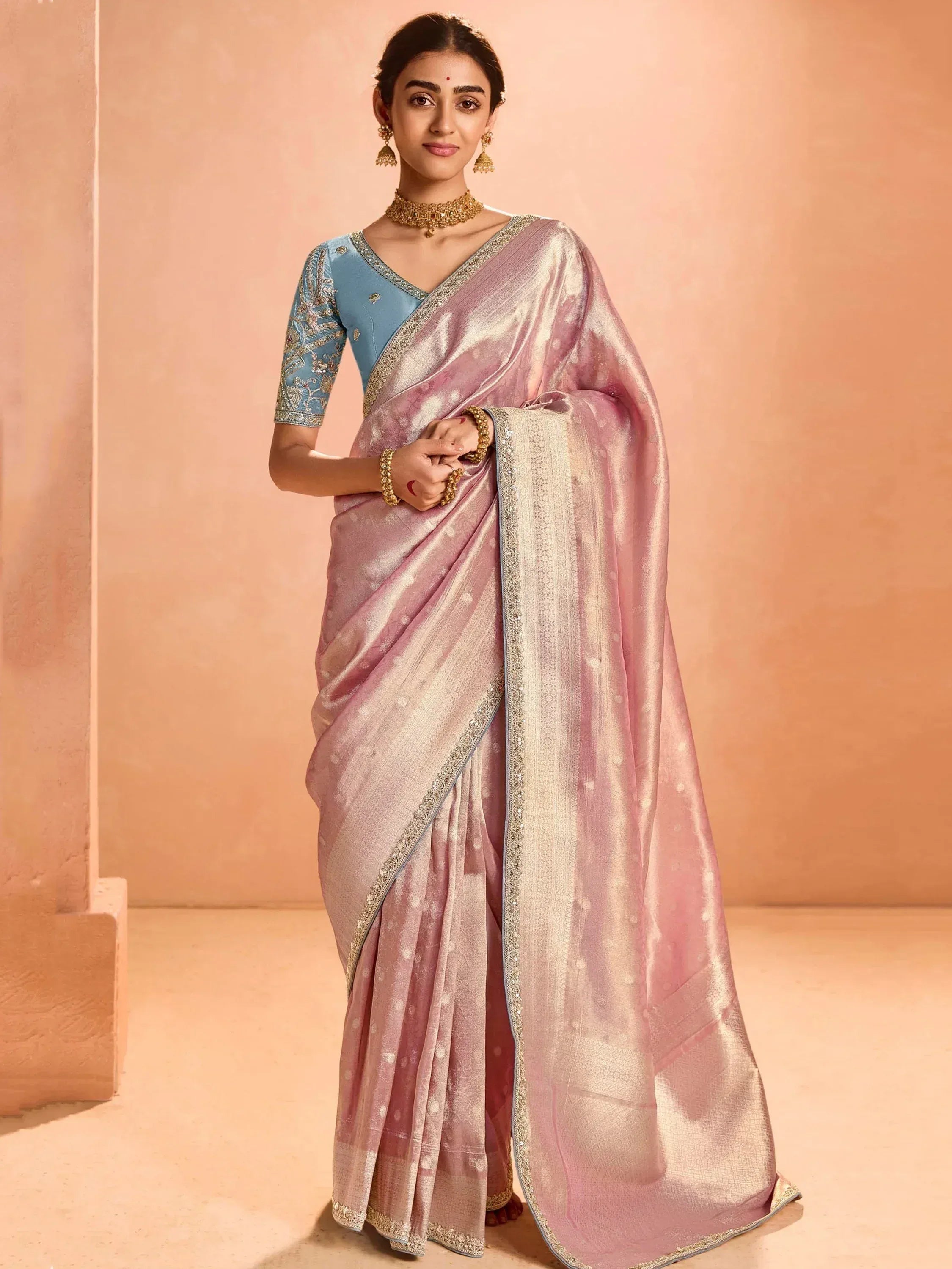 Elegant pink saree with gold border and blue embroidered blouse, perfect for Indian ethnic wear