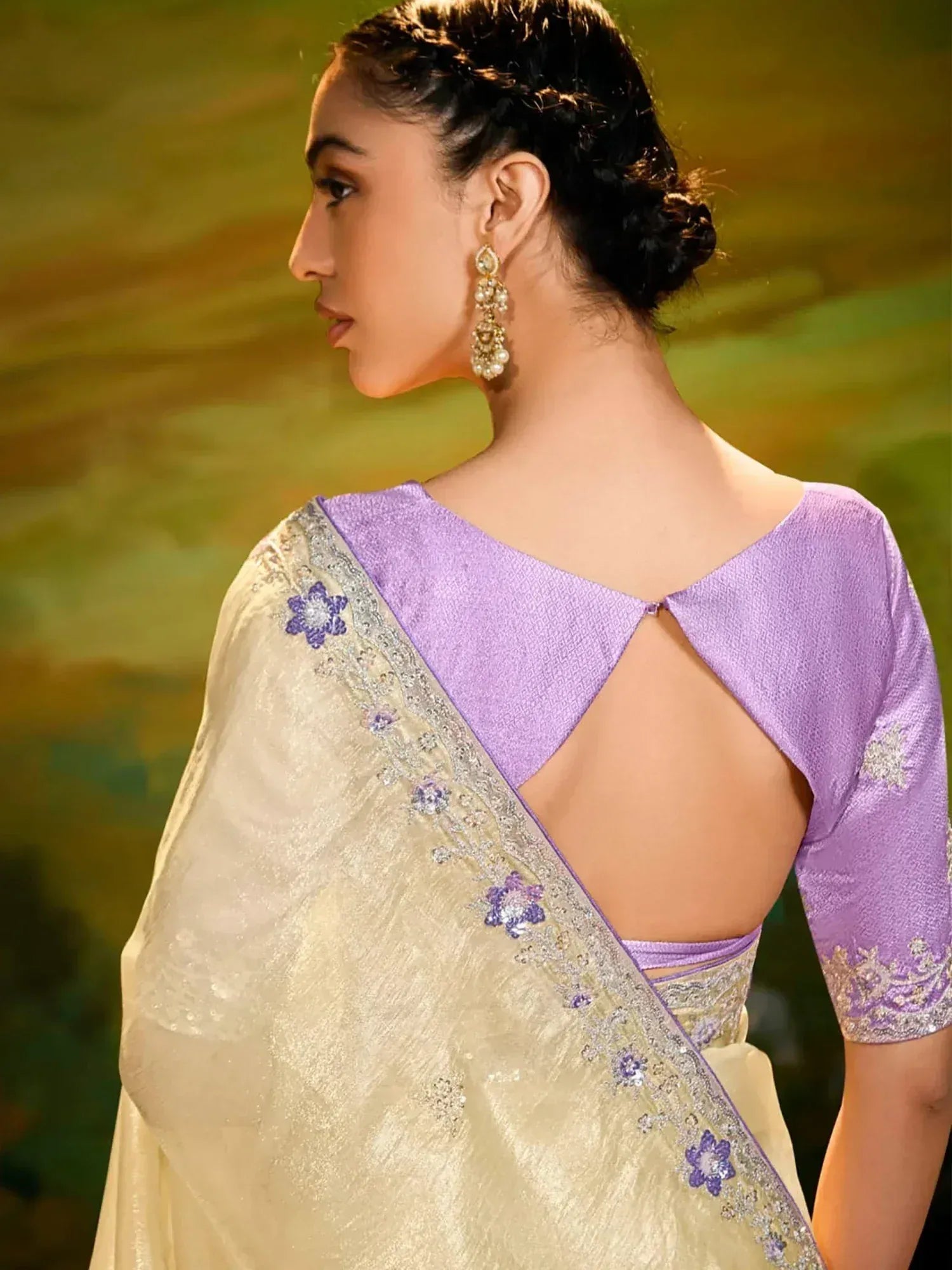 Elegant cream saree with purple floral embroidery and backless blouse, perfect for Indian ethnic occasions.