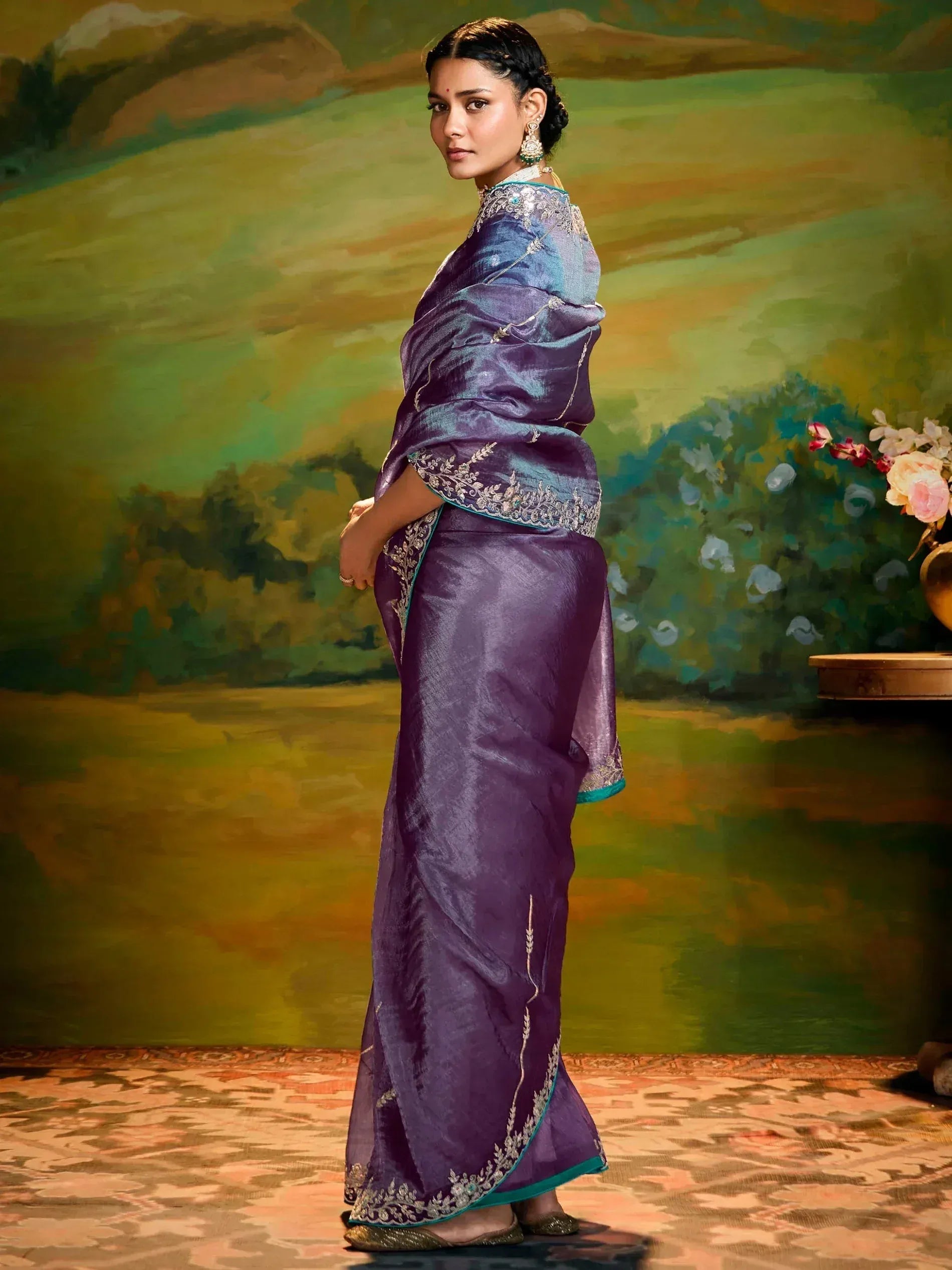 Purple silk saree with silver embroidery and teal border, styled with traditional jewelry for ethnic occasions