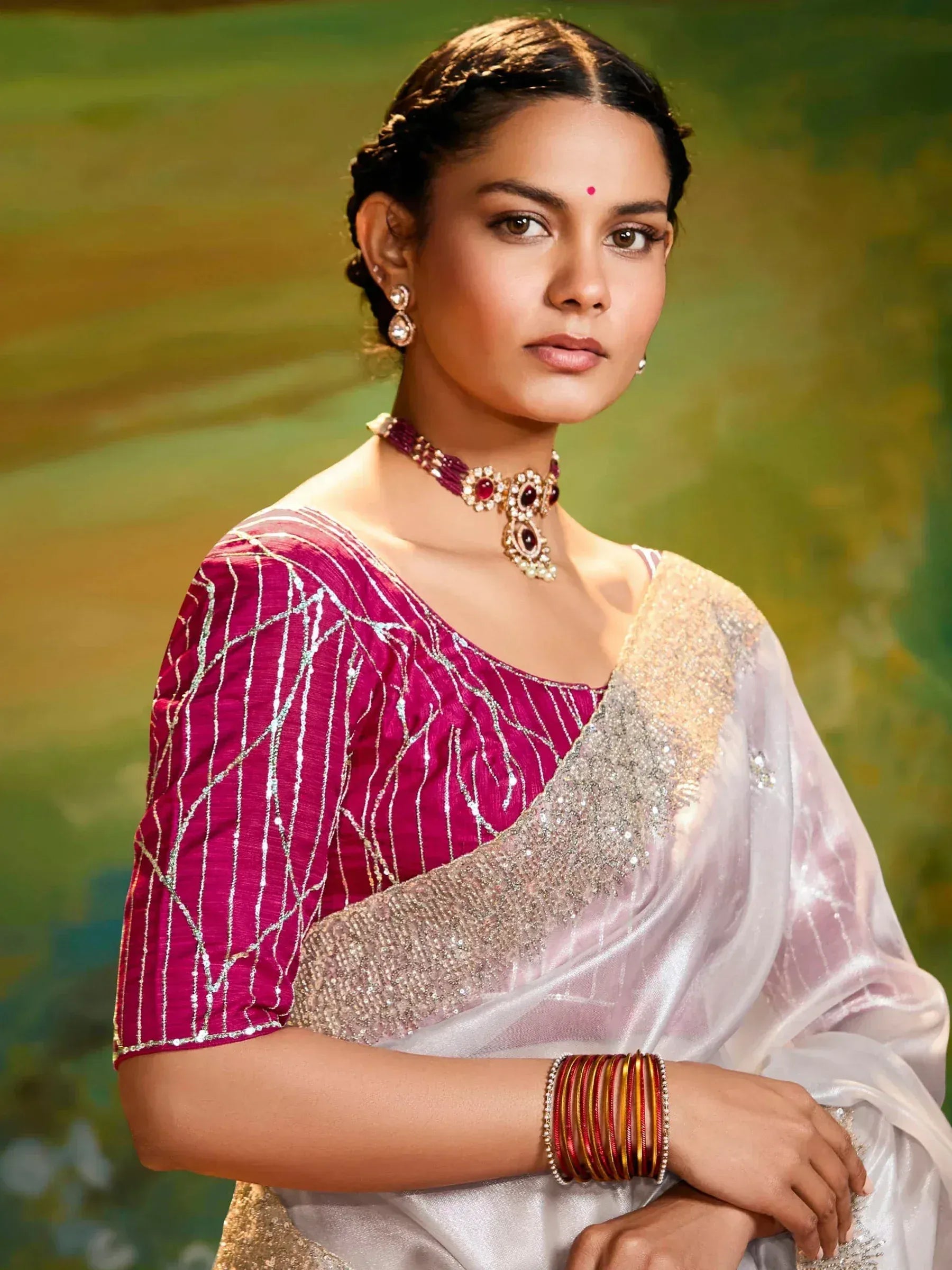 Woman in elegant white saree with silver embellishments and pink blouse, styled with traditional Indian jewelry for festive occasions
