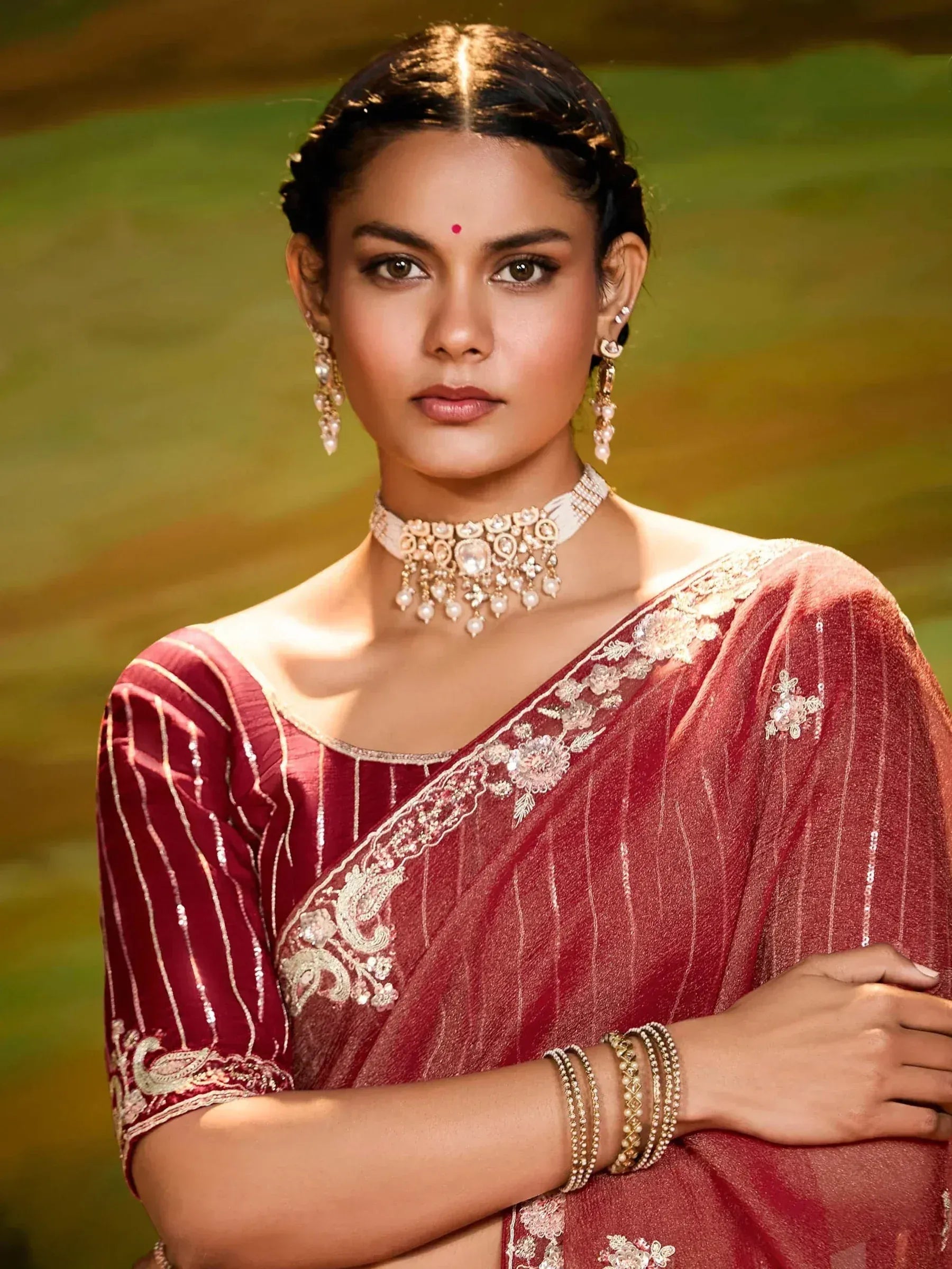 Woman in maroon embroidered saree with gold jewelry, traditional Indian ethnic wear