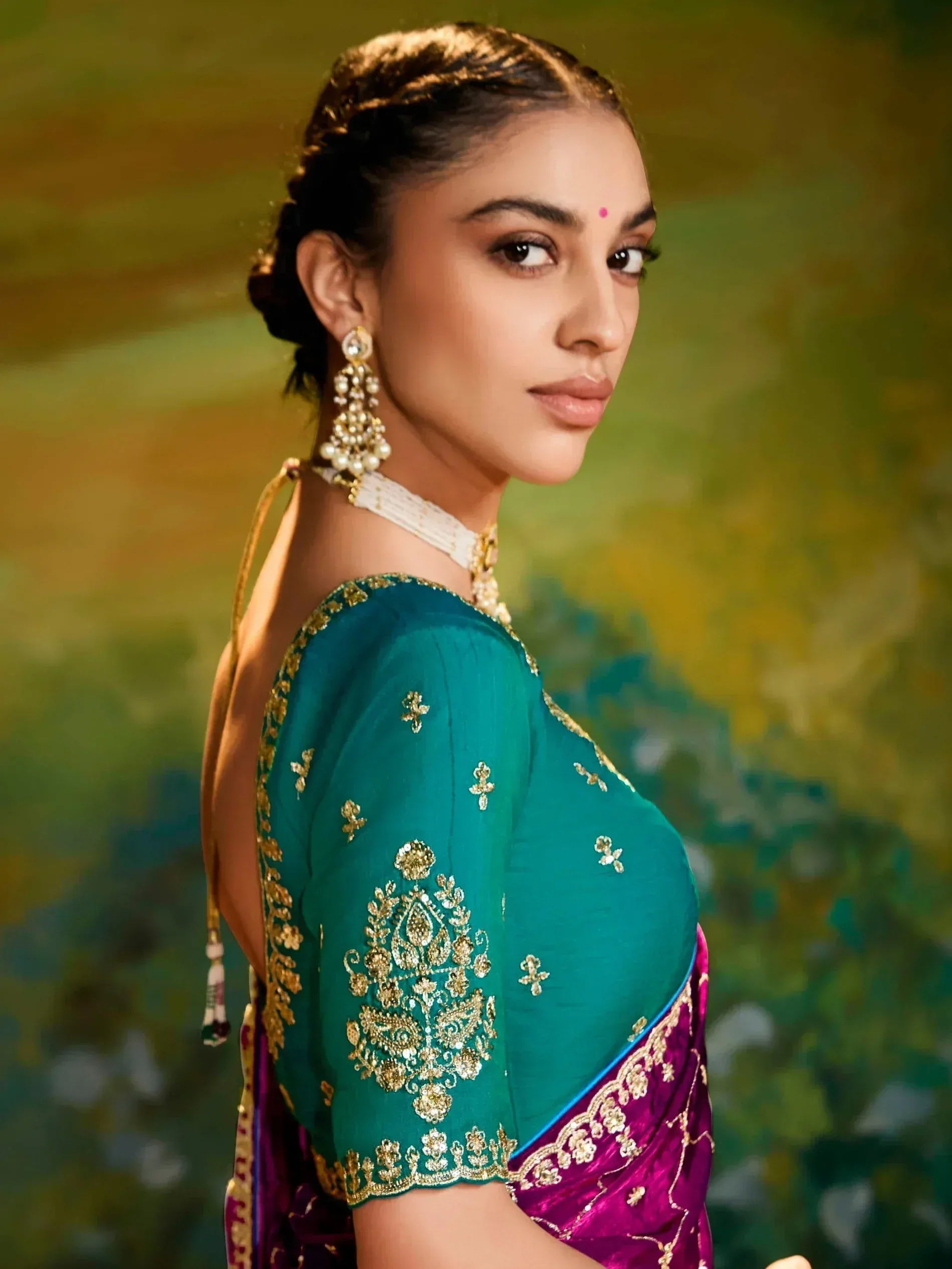 Woman in teal and magenta saree with gold embroidery, traditional Indian ethnic wear