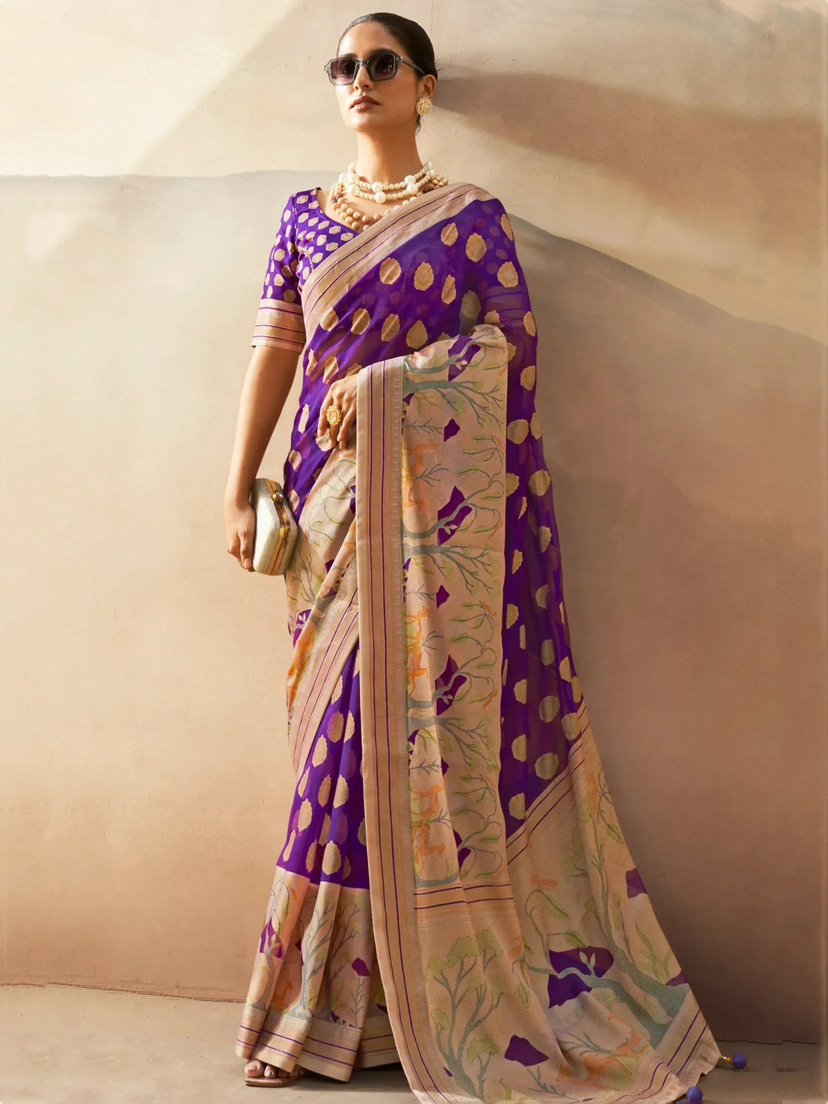 Purple and beige printed saree with floral motifs, styled with pearl jewelry and sunglasses for ethnic wear.