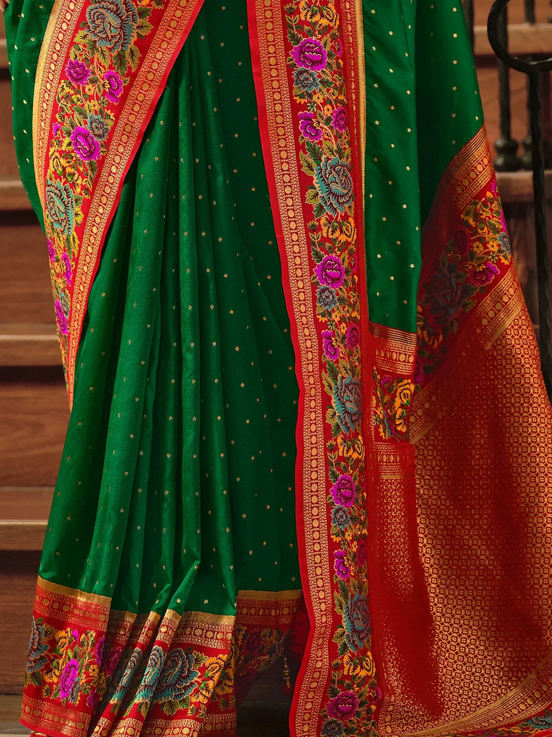 Green and red Indian saree with floral embroidery and gold zari border, perfect for festive occasions.