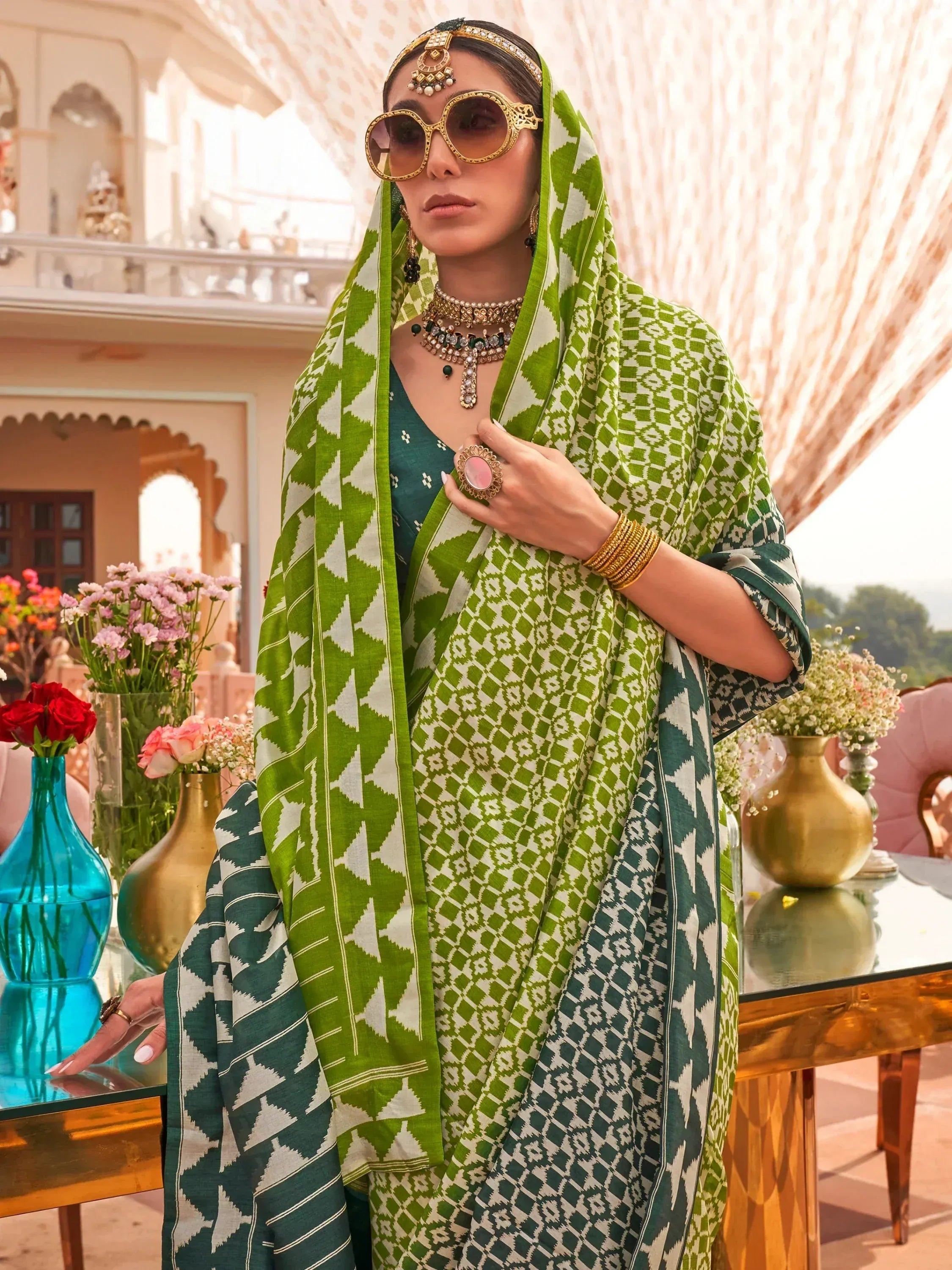 Green and white ikat print Indian ethnic saree with gold jewelry and sunglasses