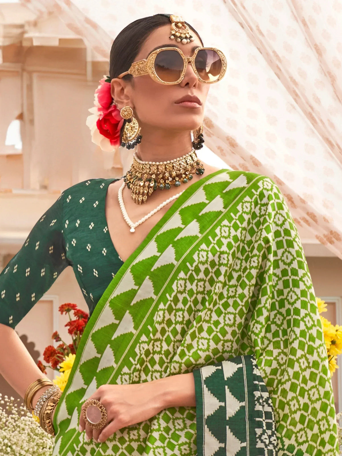 Green and white patterned saree with ethnic jewelry and floral hair accessory