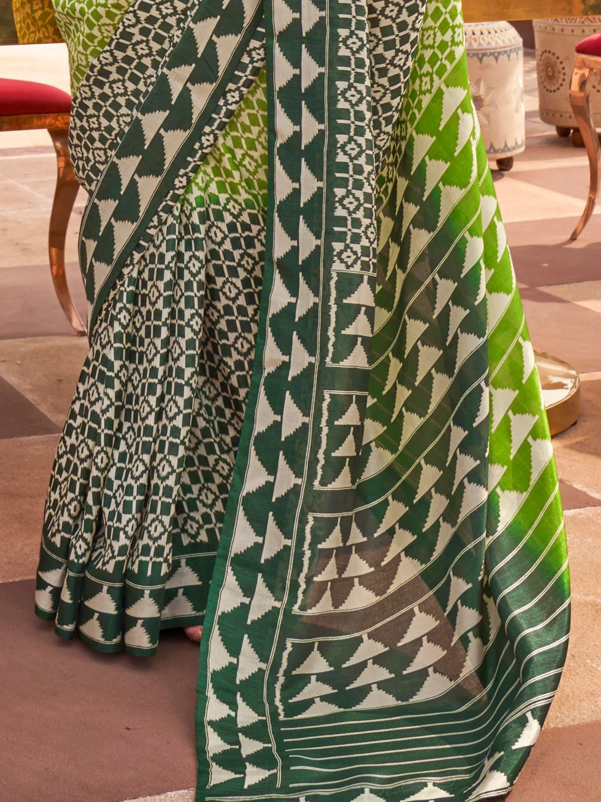Green and white geometric patterned saree with ethnic ikat design, perfect for traditional occasions.