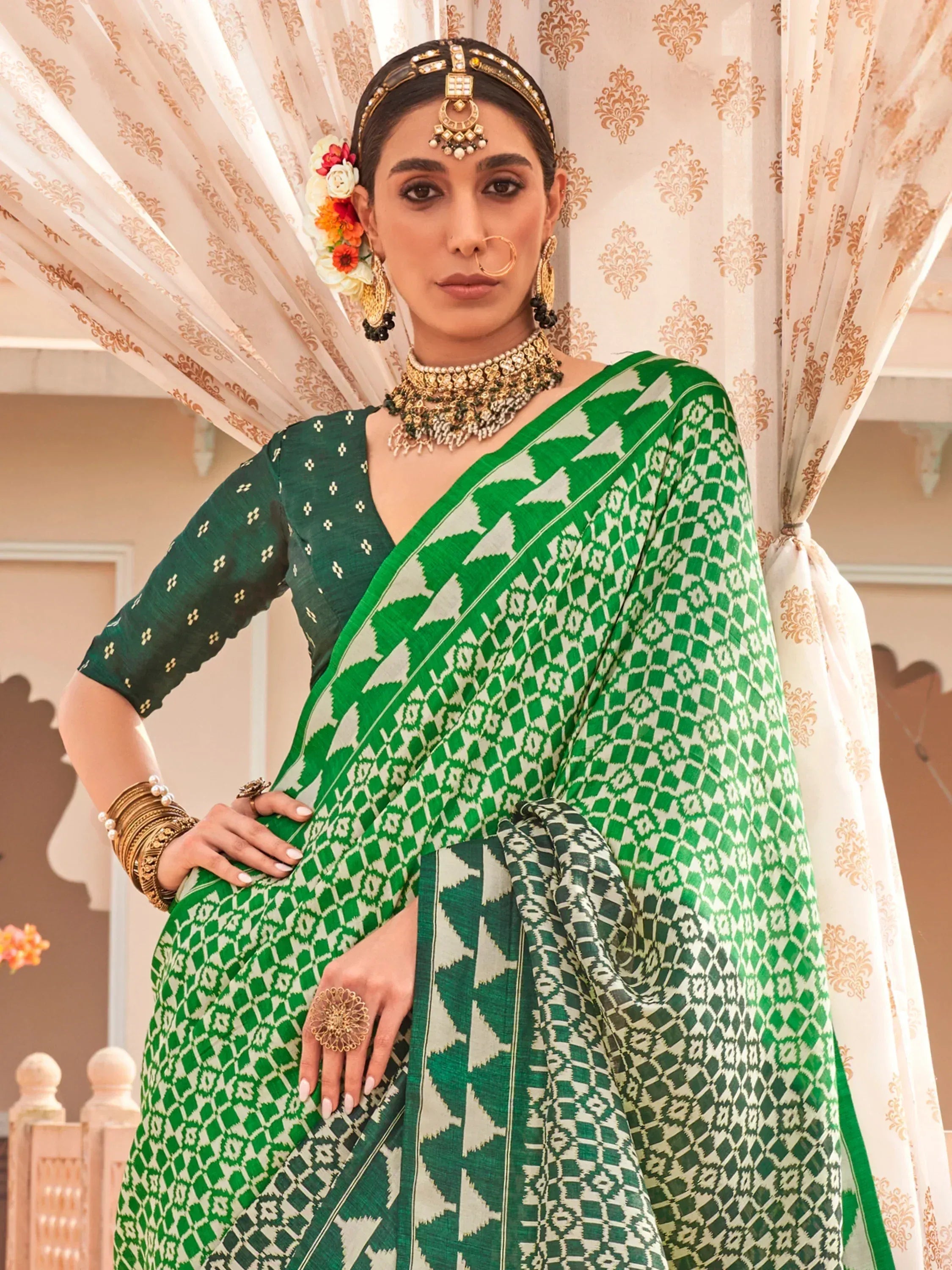 Green and white ikat saree with traditional Indian jewelry and floral hair accessories