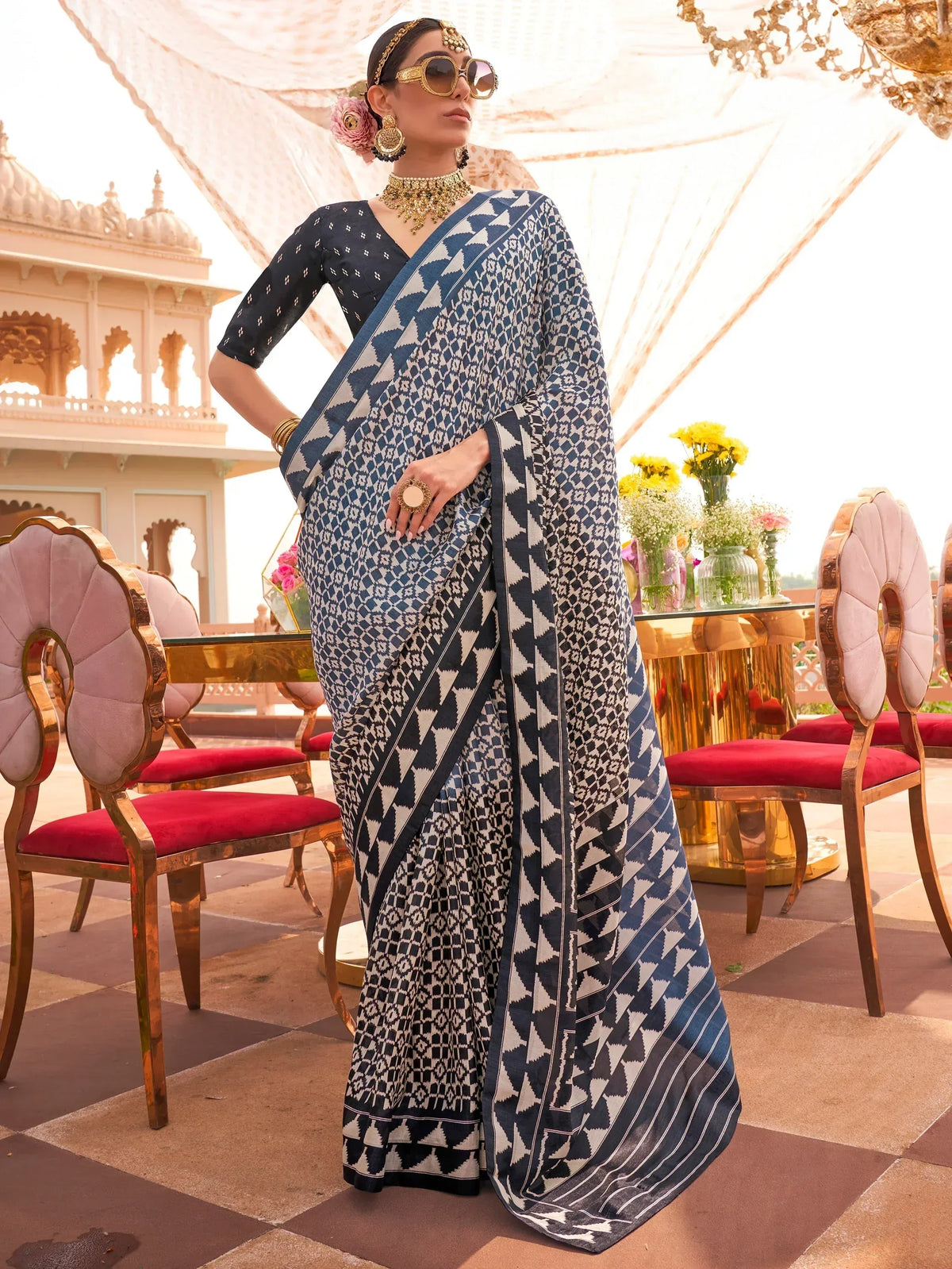 Woman in blue and white geometric print saree with gold jewelry, styled for Indian ethnic wear