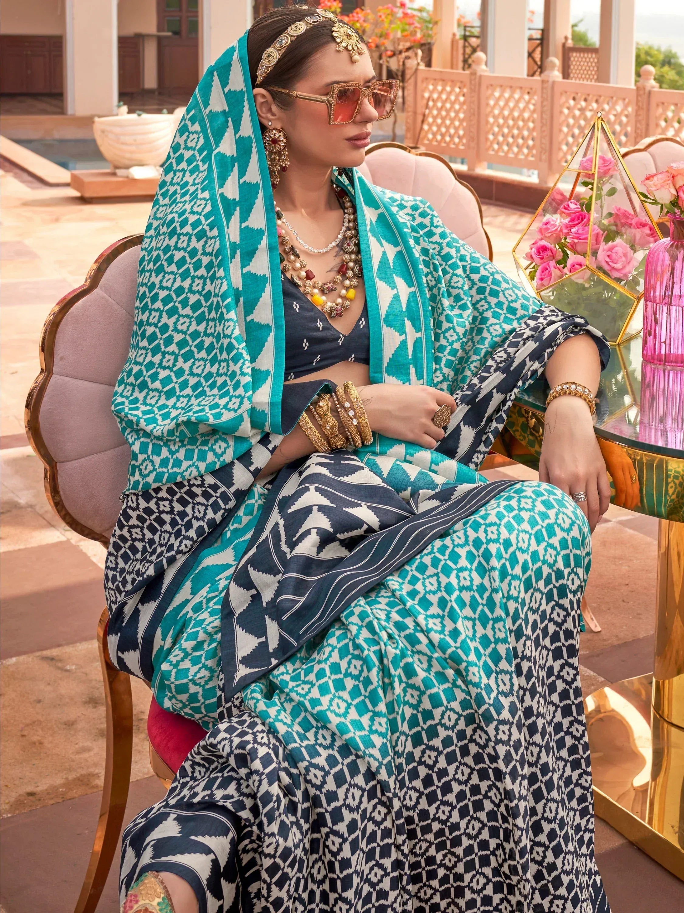 Woman in teal and navy ikat print salwar kameez with ethnic jewelry, styled for festive occasions