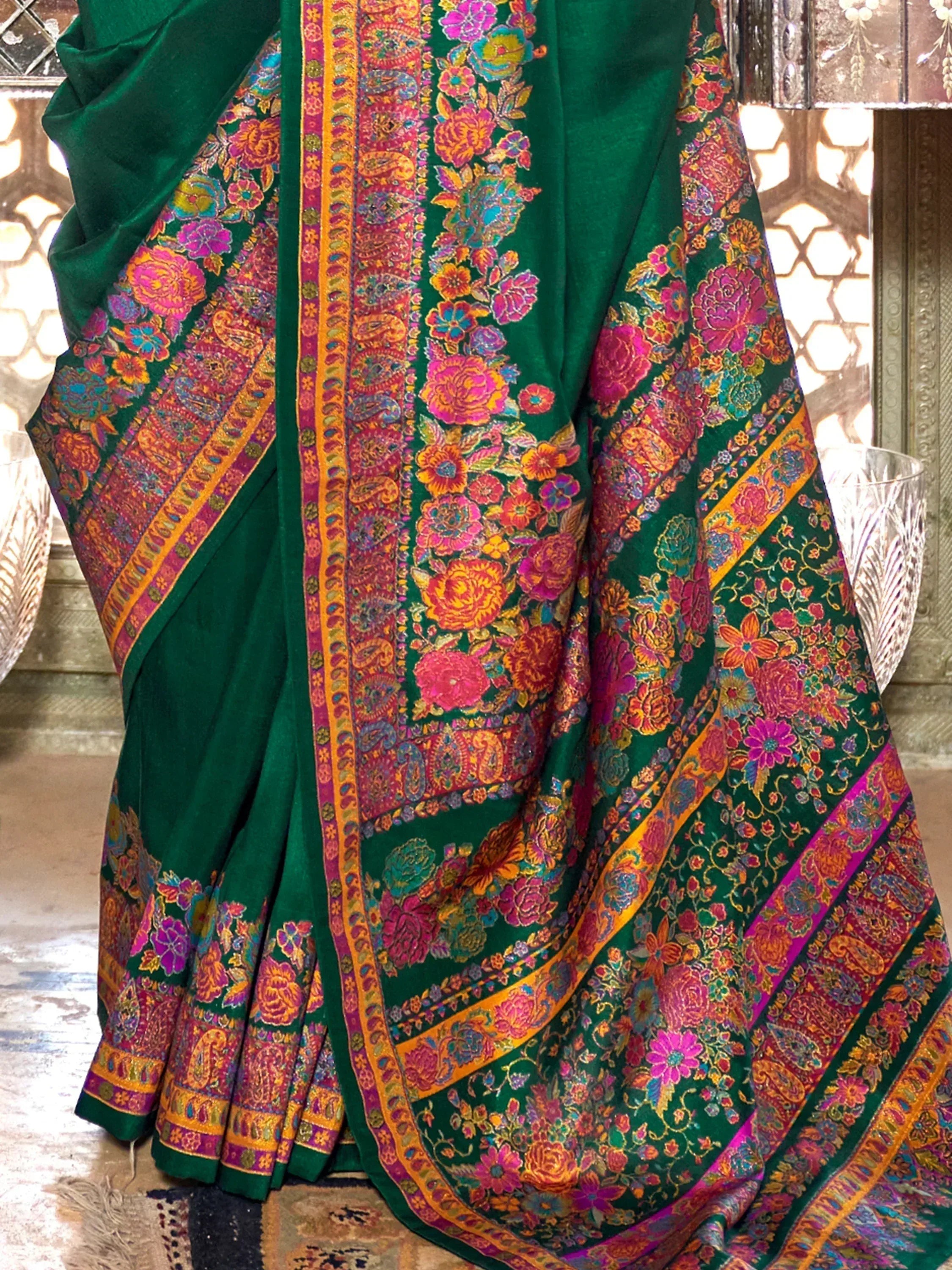 Emerald green saree with vibrant floral and paisley embroidery, perfect for Indian ethnic wear occasions.