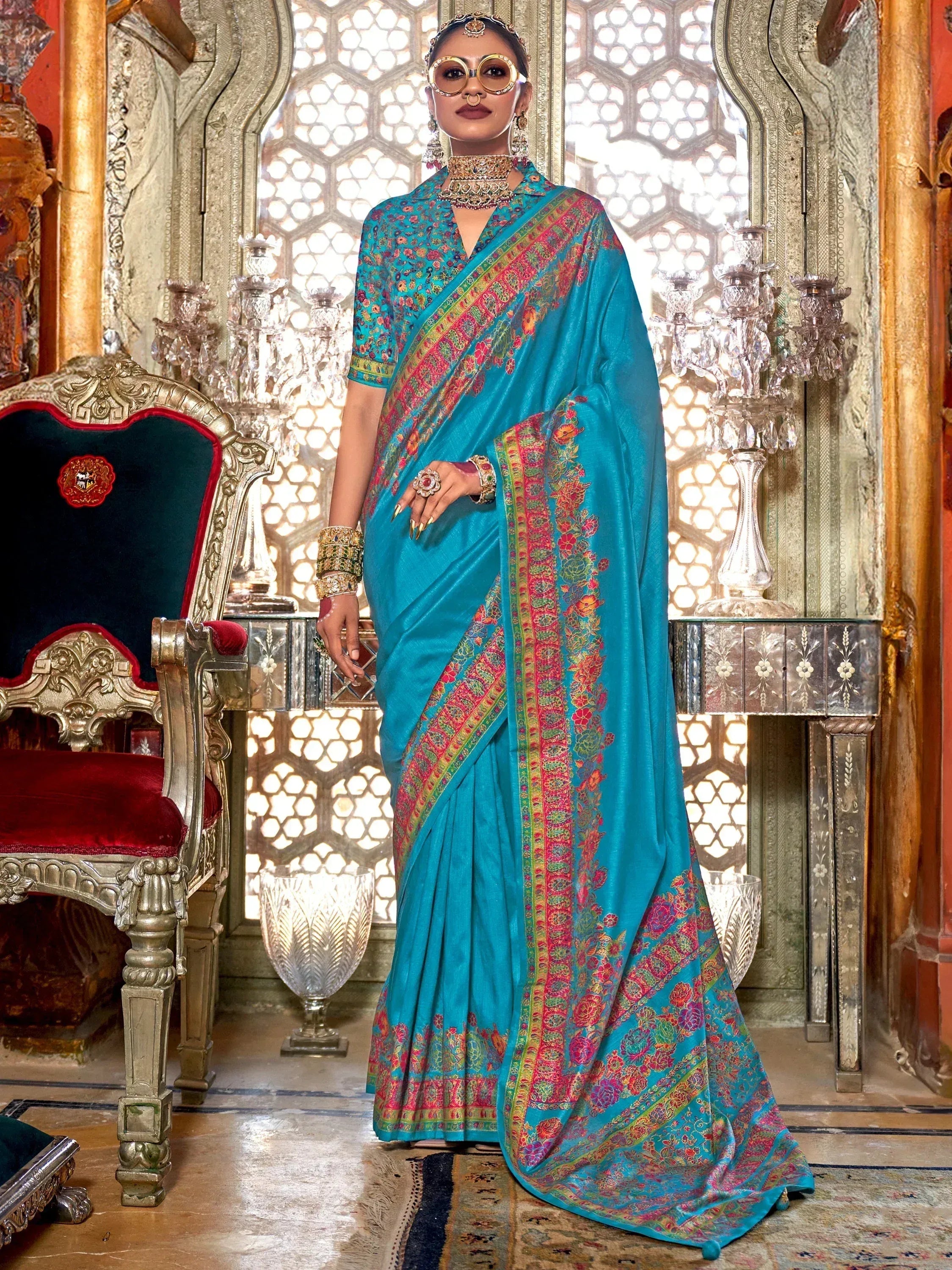 Turquoise floral saree with embroidered border, styled with traditional Indian jewelry for festive occasions