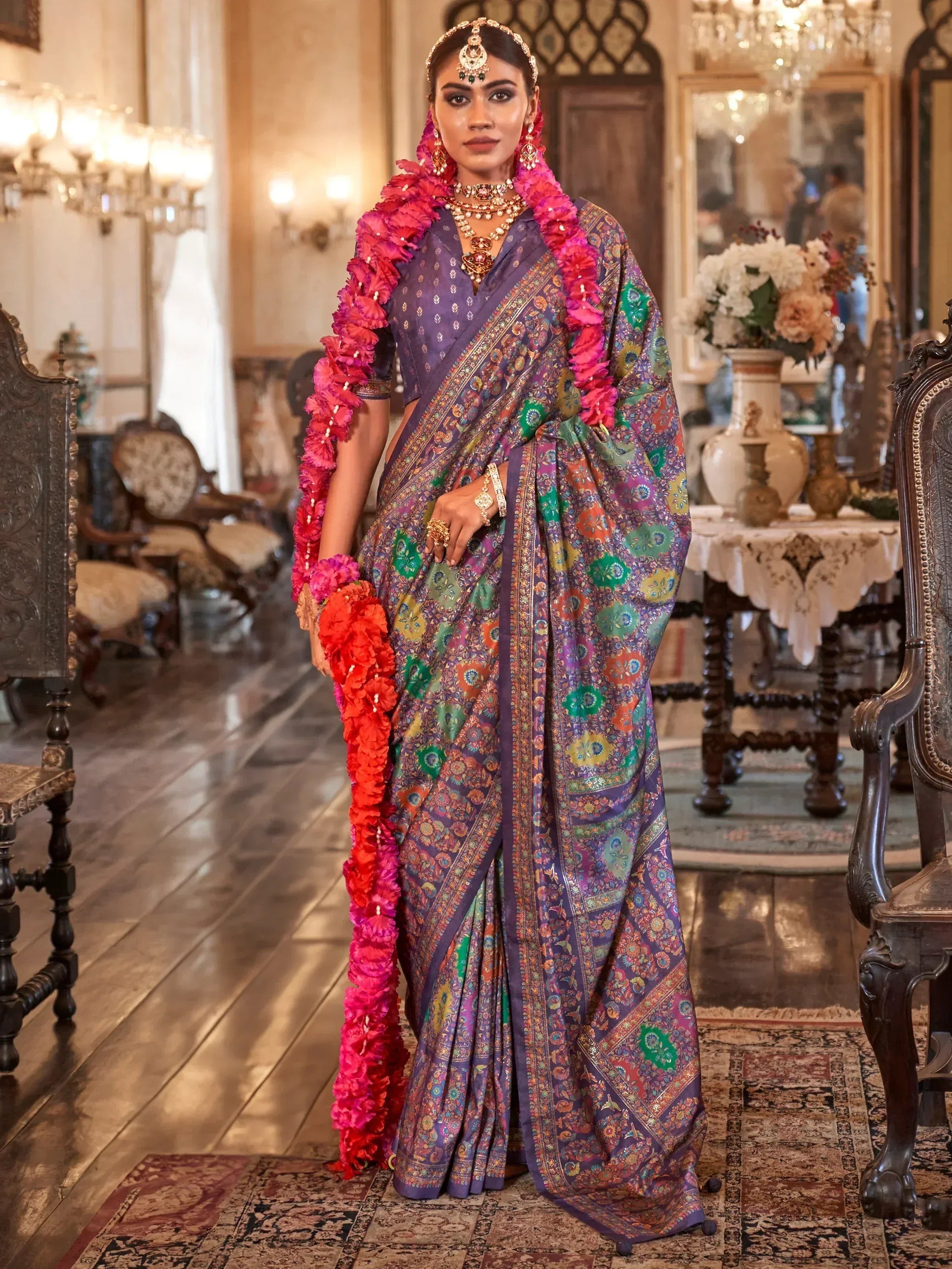 Elegant woman in purple floral saree with pink garland, traditional Indian ethnic wear