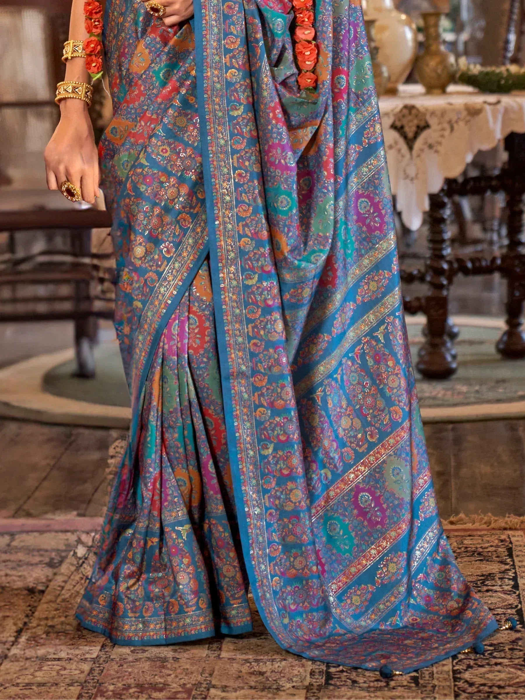 Vibrant blue printed saree with intricate floral patterns, perfect for ethnic occasions and traditional wear.