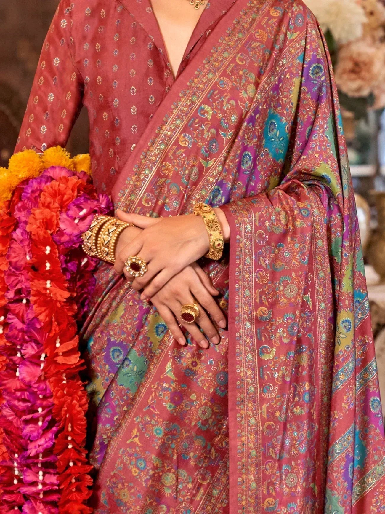 Elegant Indian saree with intricate floral patterns and gold jewelry, perfect for festive occasions.
