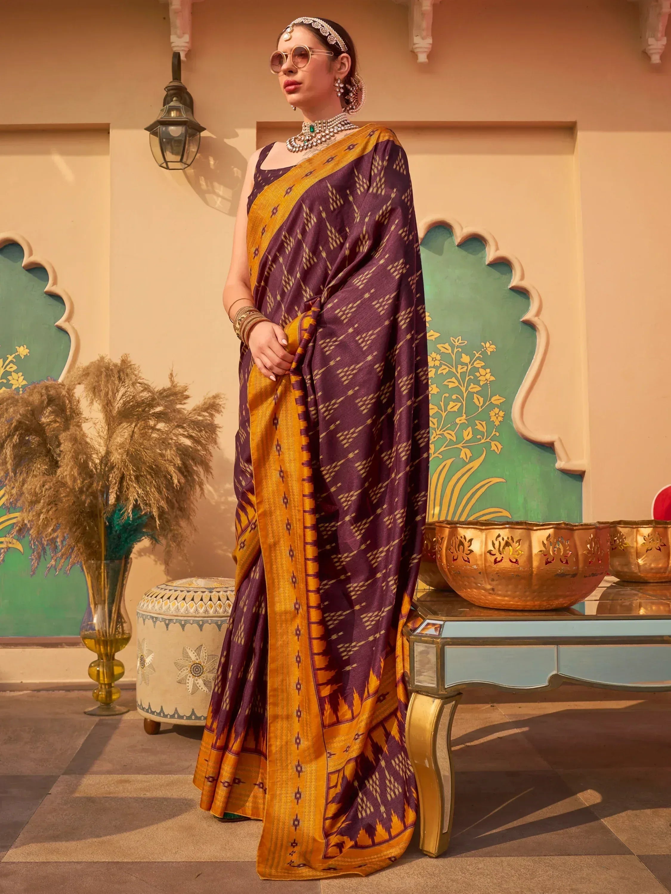 Purple and gold ethnic saree with geometric ikat print, styled with traditional jewelry for festive occasions