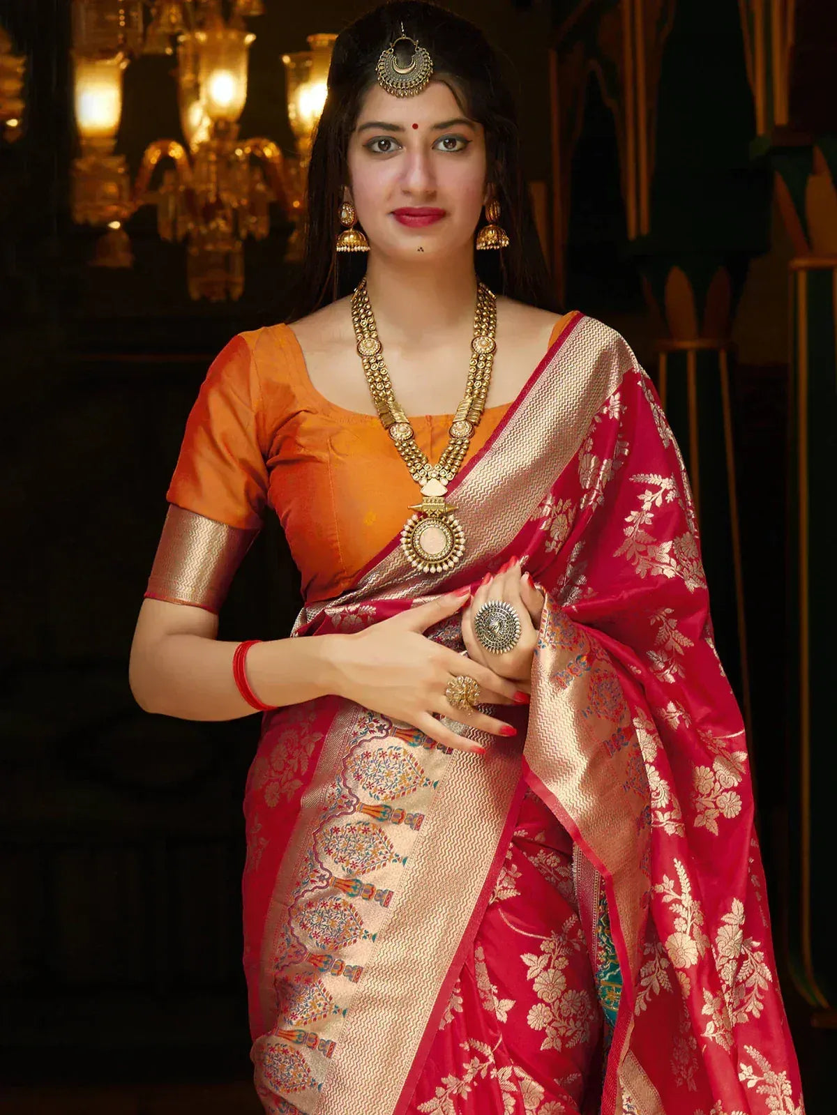 Woman in red and gold designer saree with orange blouse, traditional Indian ethnic wear, heavy jewelry