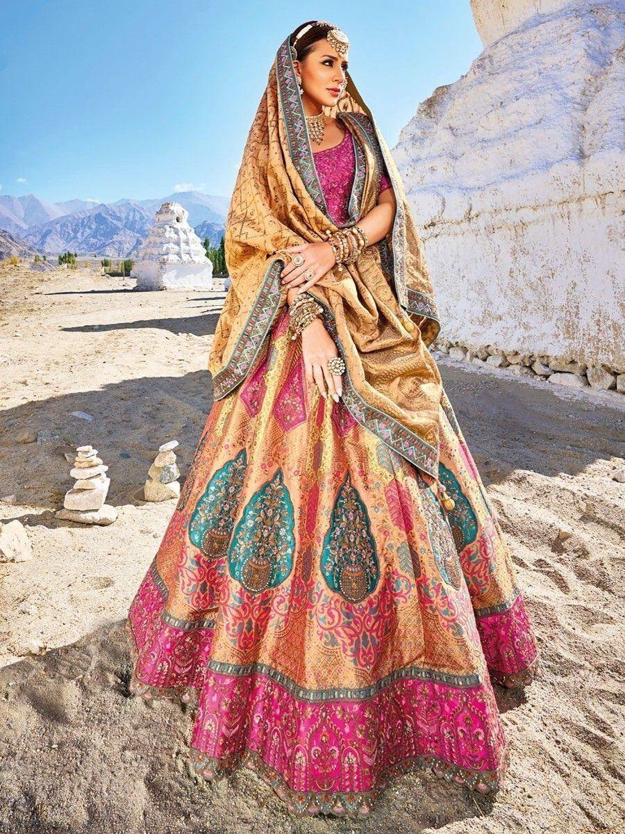 Elegant Indian bridal lehenga choli with pink and gold embroidery, styled with dupatta in desert landscape