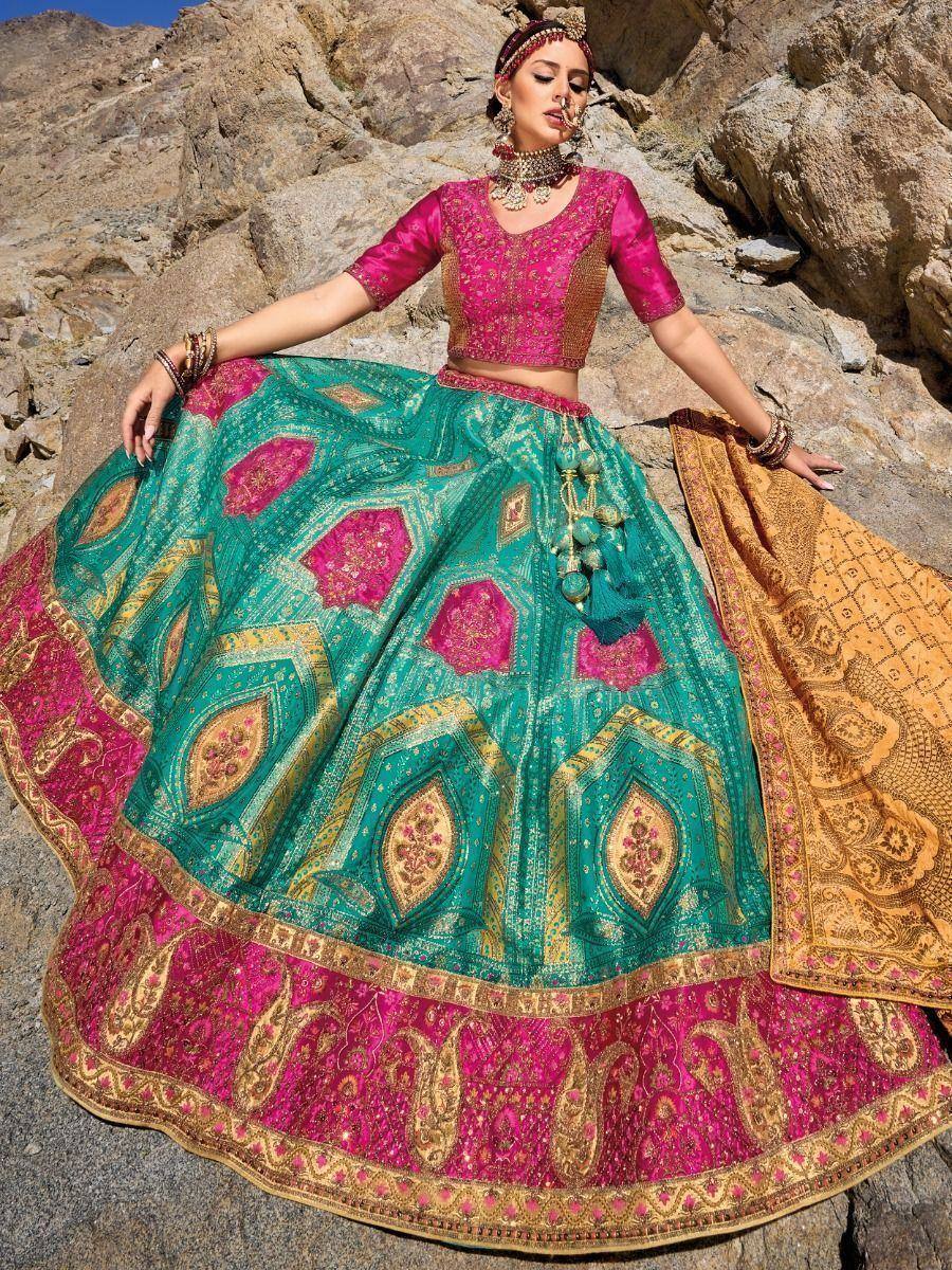 Vibrant pink and teal designer lehenga choli with gold embroidery, perfect for Indian ethnic wear occasions.