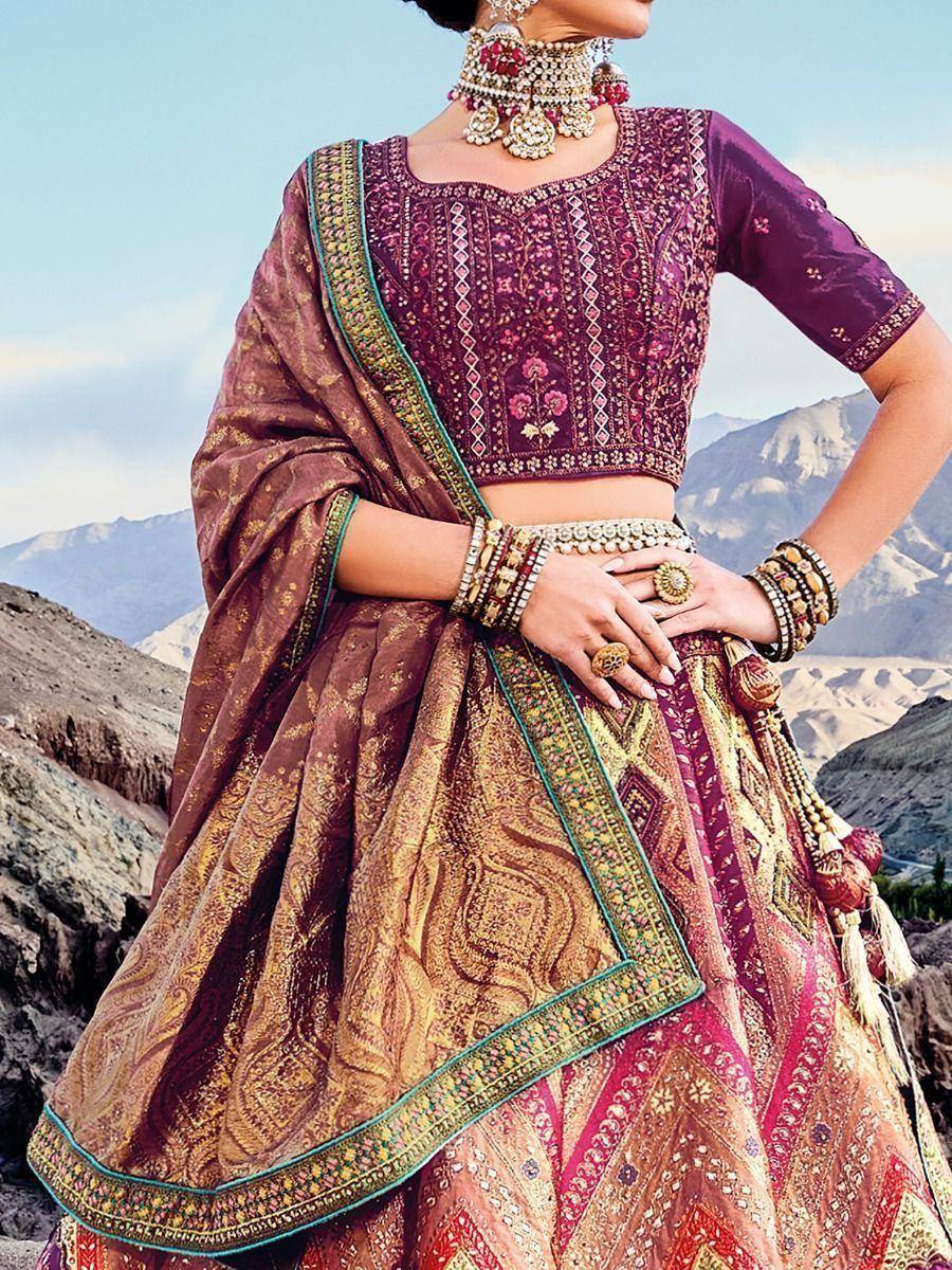 Elegant purple and gold embroidered lehenga choli with heavy jewelry, perfect for Indian weddings and festive occasions.
