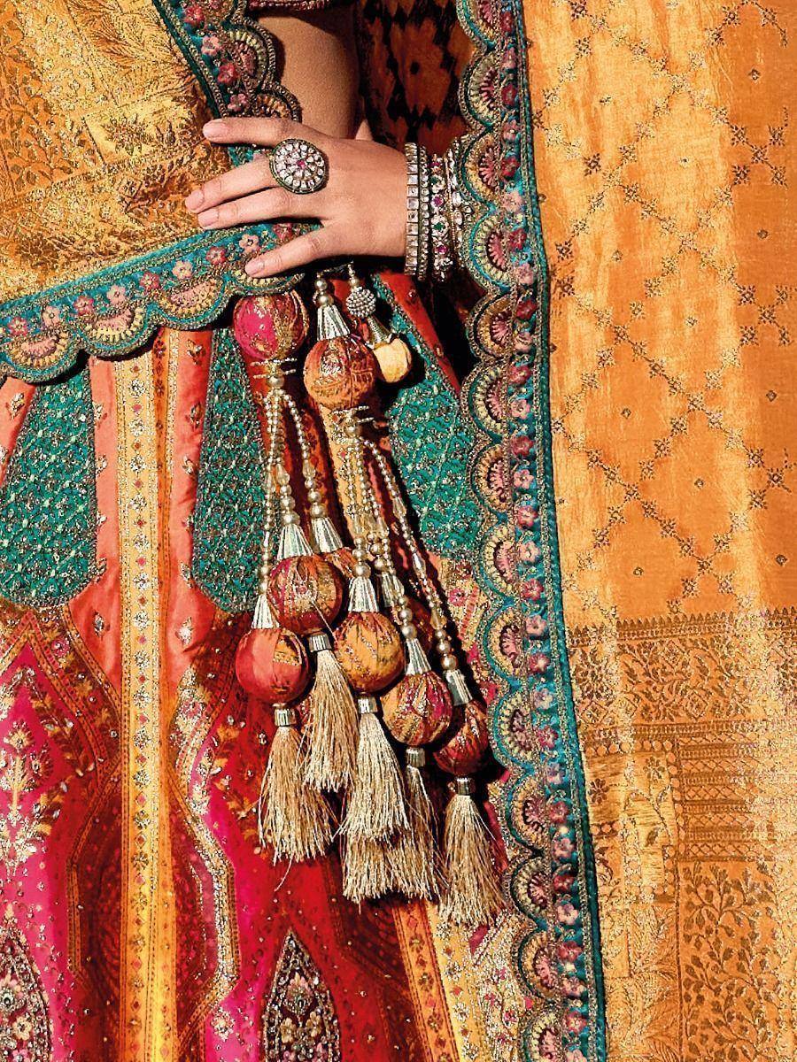 Indian ethnic lehenga choli with intricate embroidery, tassels, and traditional jewelry details