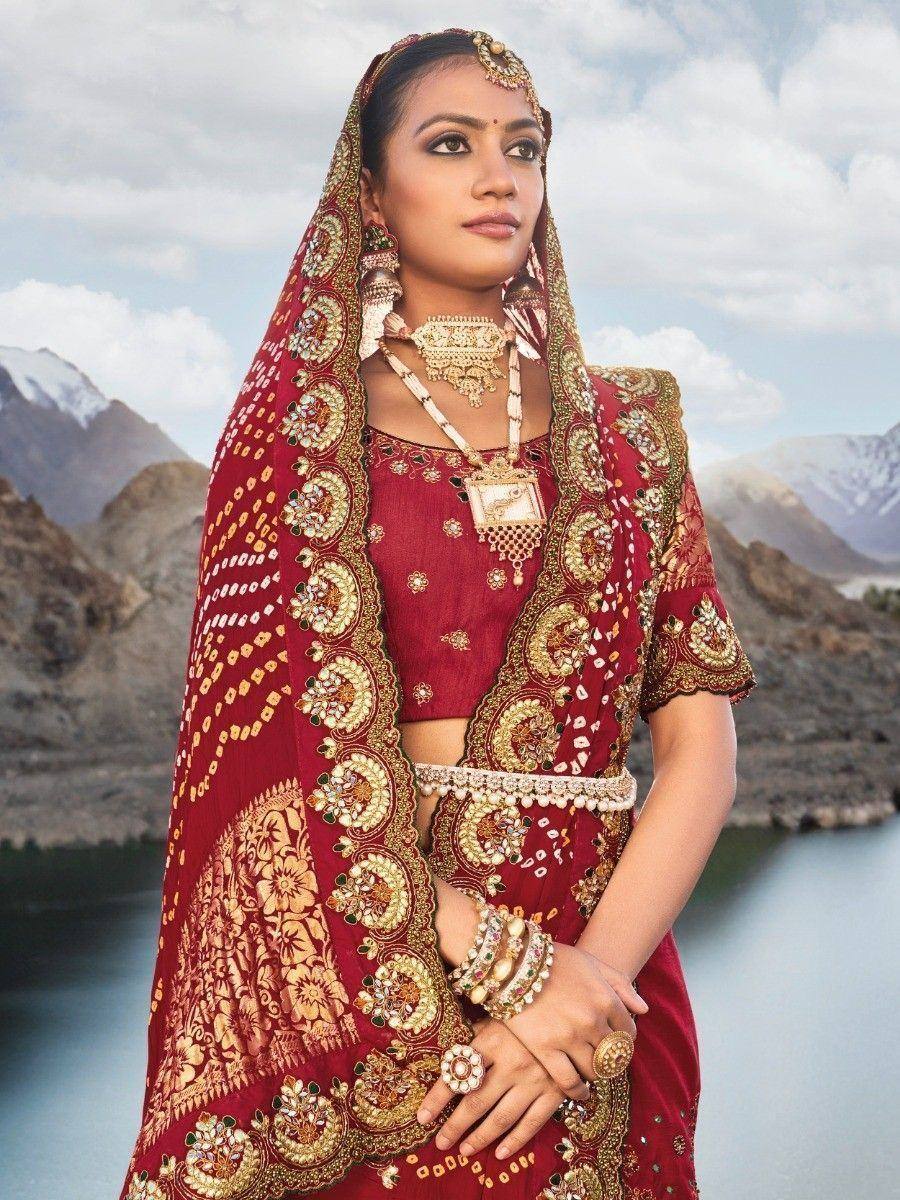 Red embroidered lehenga choli with gold work, traditional Indian bridal wear, mountain backdrop
