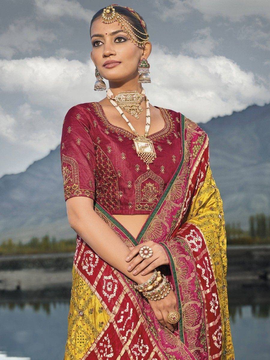 Woman in maroon and gold embroidered lehenga choli with traditional jewelry, mountain backdrop
