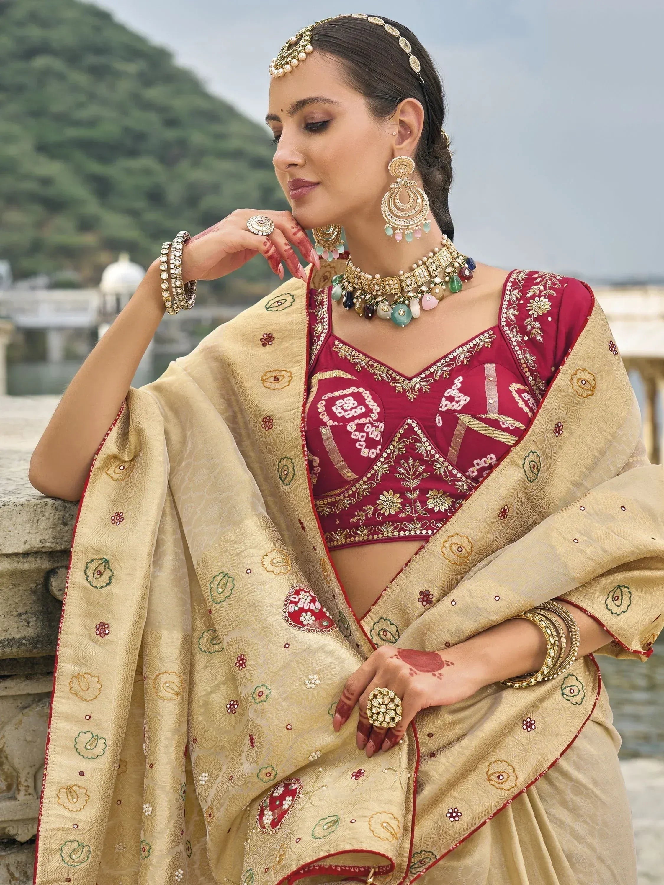 Elegant Indian ethnic wear: maroon embroidered blouse with gold floral dupatta, traditional jewelry, henna hands