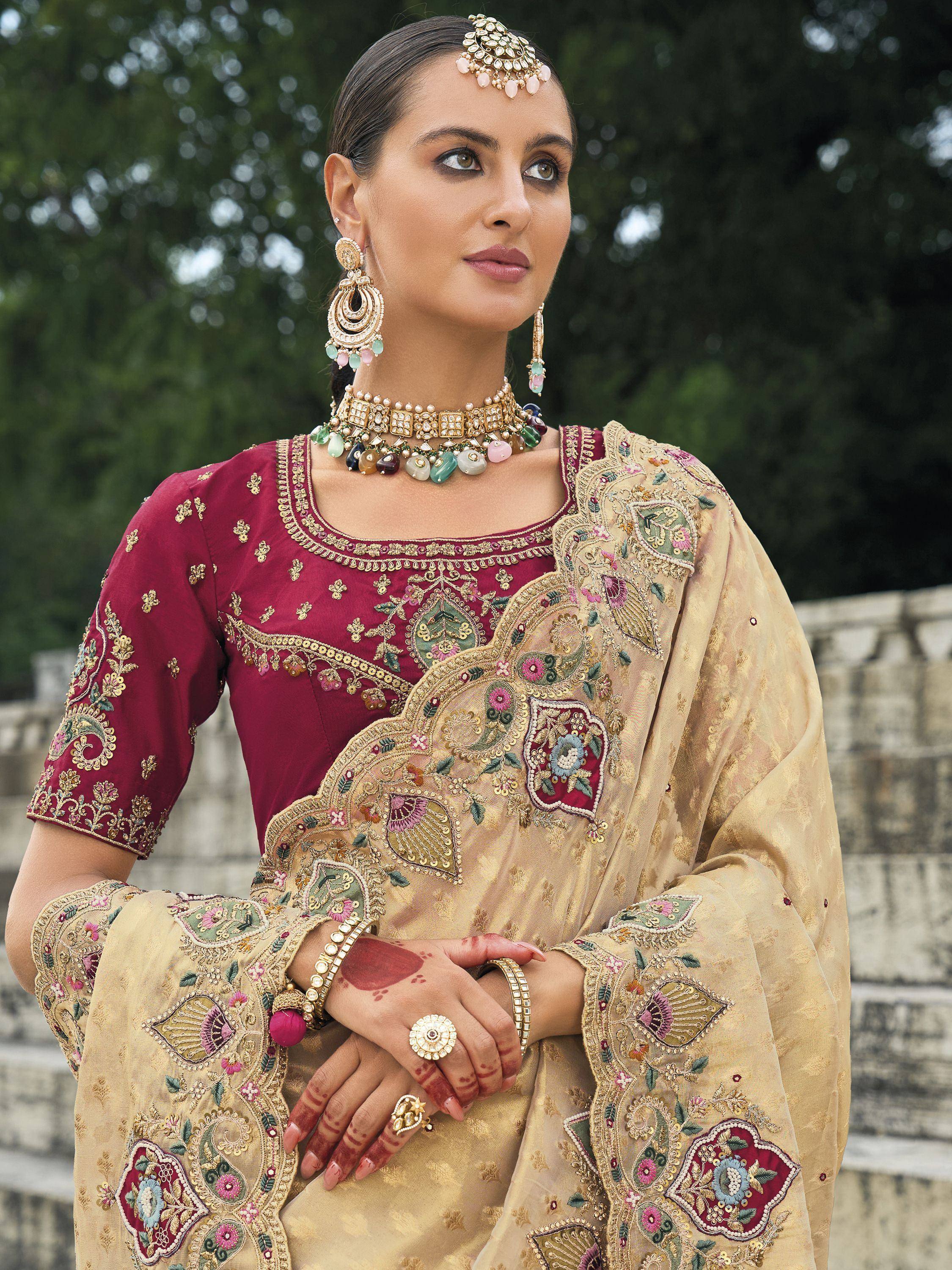Elegant maroon and gold embroidered salwar kameez with floral motifs, traditional jewelry, and henna designs