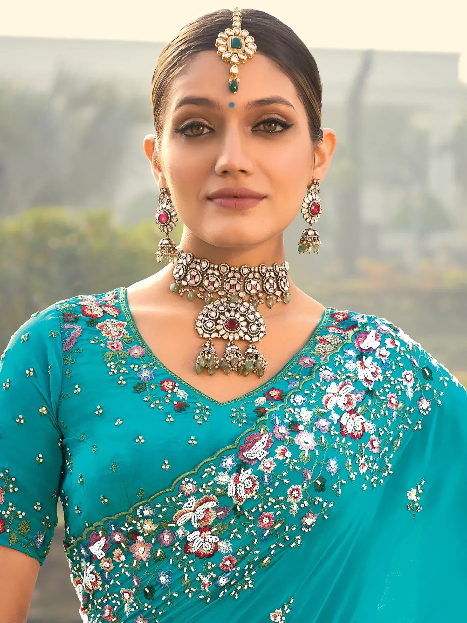 Teal floral embroidered saree with traditional Indian jewelry for ethnic wear