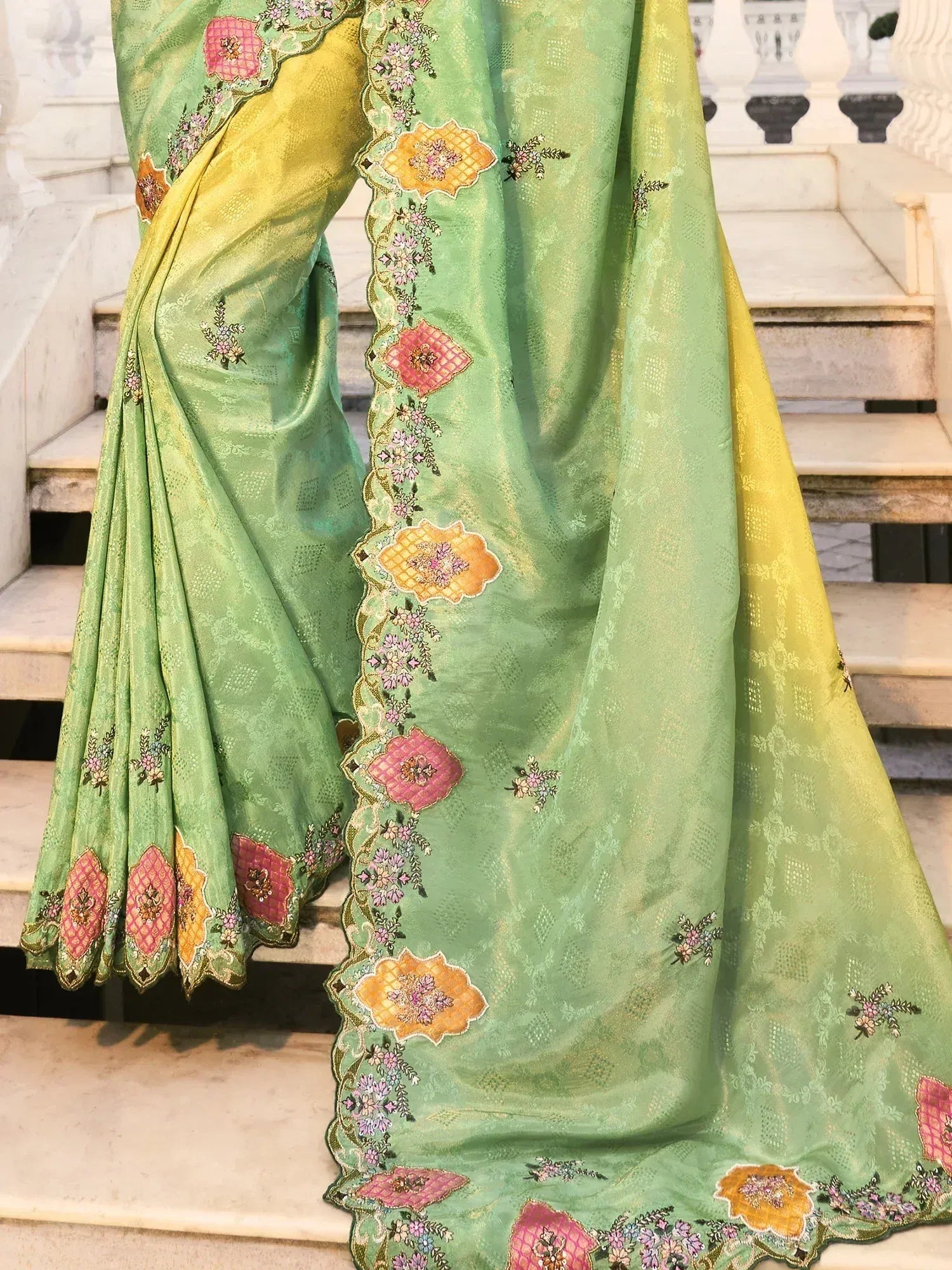 Green floral embroidered saree with pink and yellow accents, ideal for ethnic occasions.