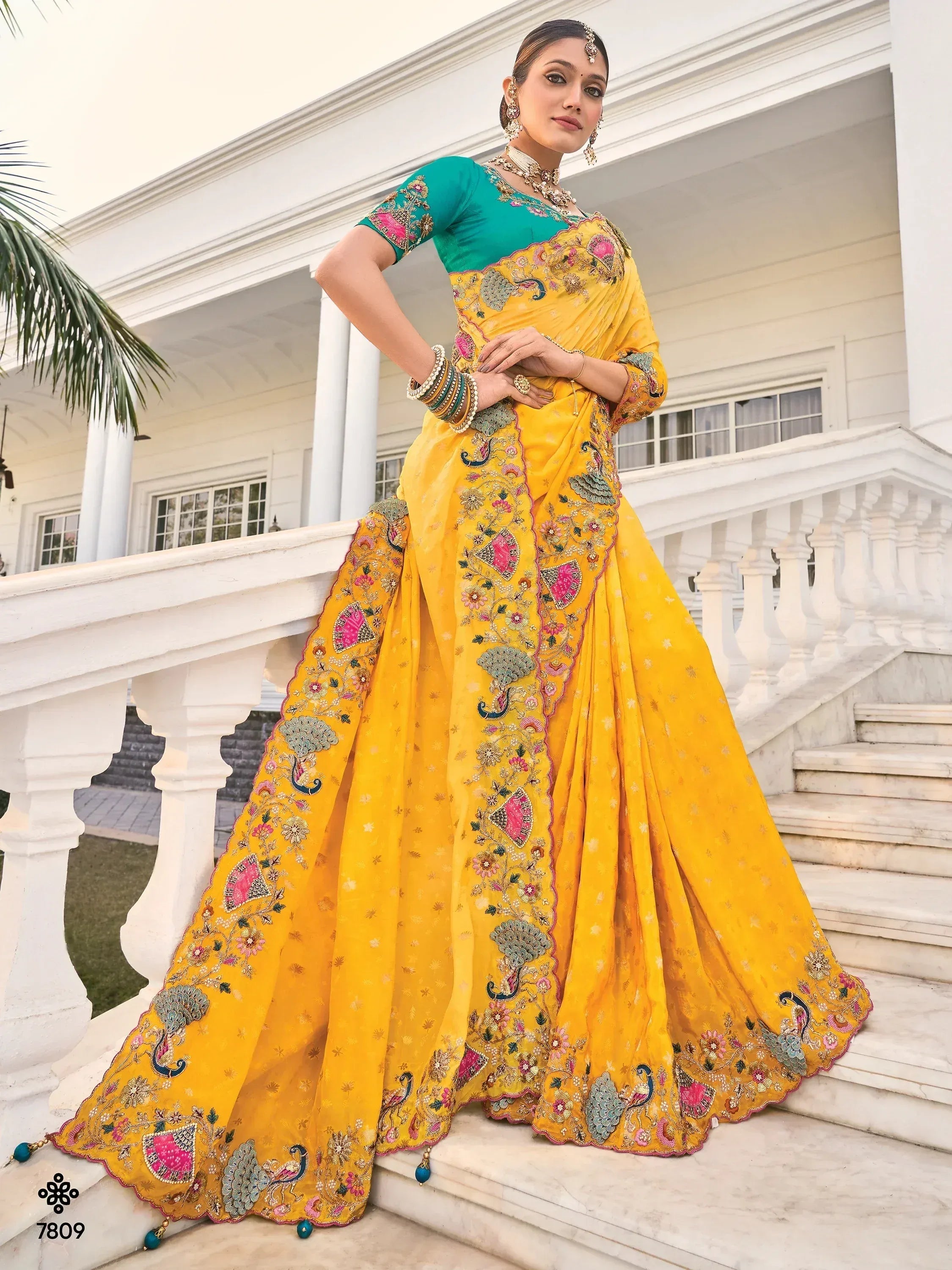 Yellow embroidered saree with peacock motifs and teal blouse, perfect for Indian ethnic wear