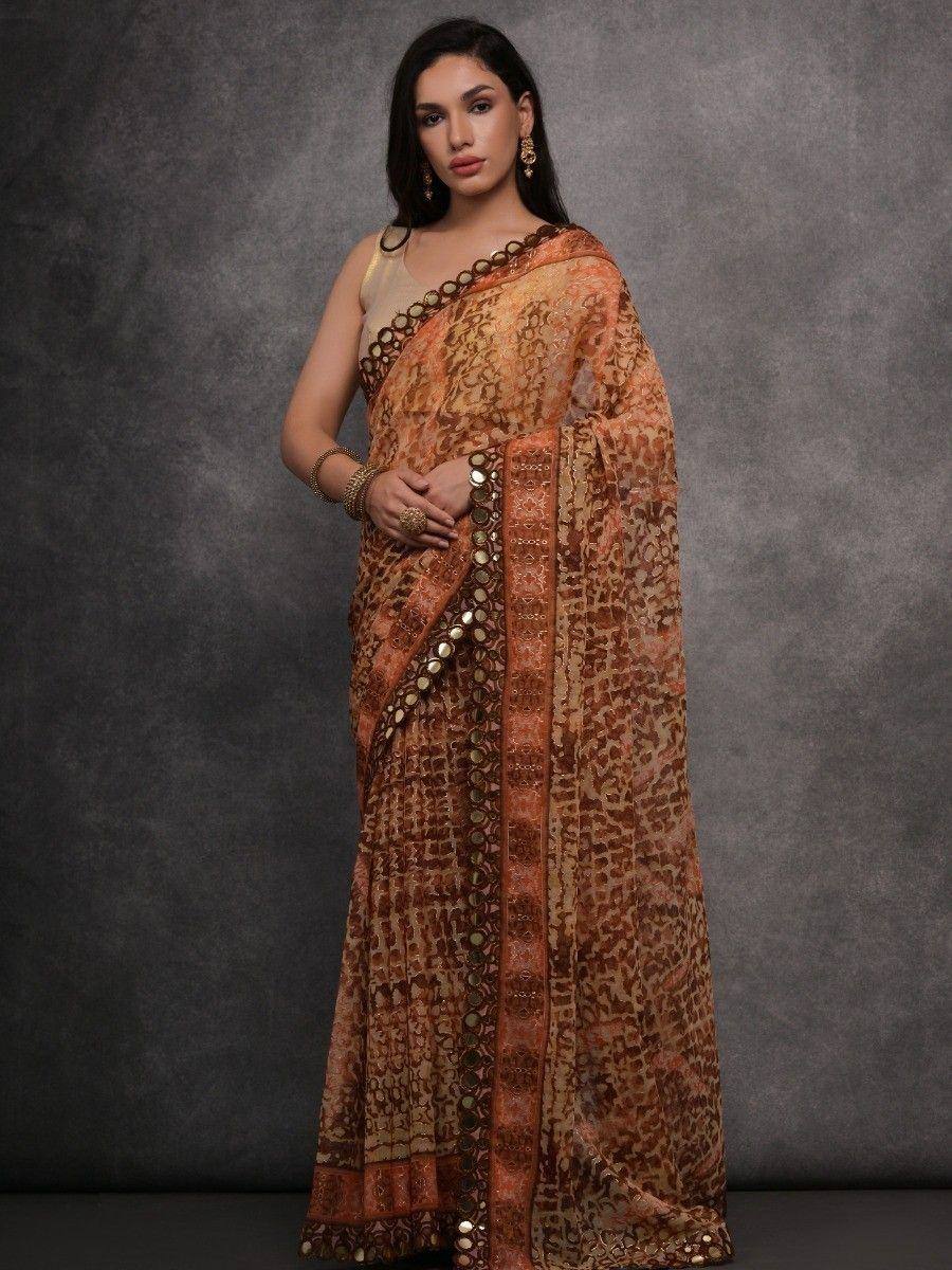Elegant orange-brown printed saree with gold mirror work, perfect for Indian ethnic occasions