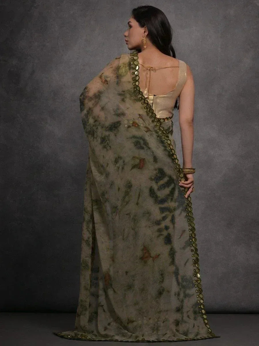 Woman in olive green floral saree with gold coin border and backless blouse, ethnic wear
