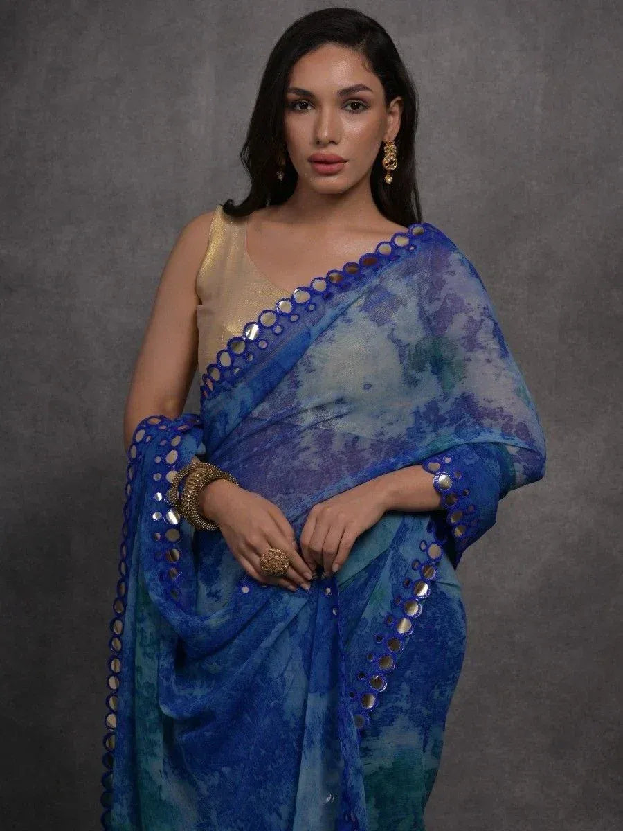Blue tie-dye saree with mirror work border, paired with gold blouse for ethnic wear