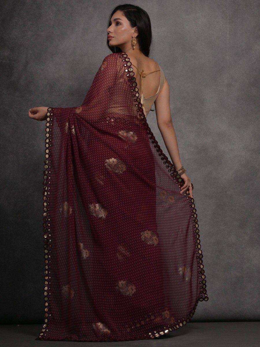Maroon sheer saree with gold motifs and circular border, styled with a beige blouse for ethnic wear.