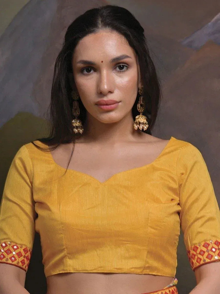 Yellow ethnic crop top with red mirror work sleeves, paired with traditional jhumka earrings
