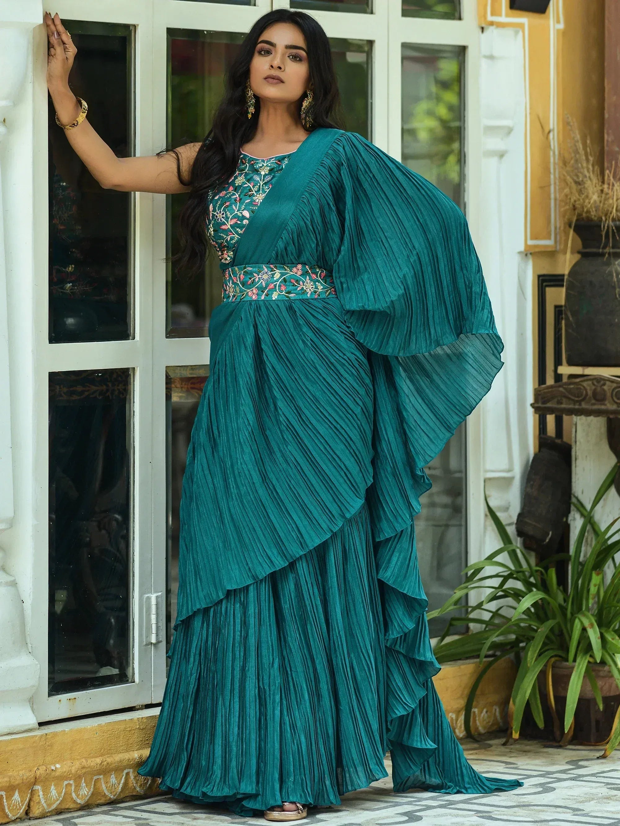 Teal pleated ethnic gown with floral embroidery, perfect for Indian festive occasions and parties.