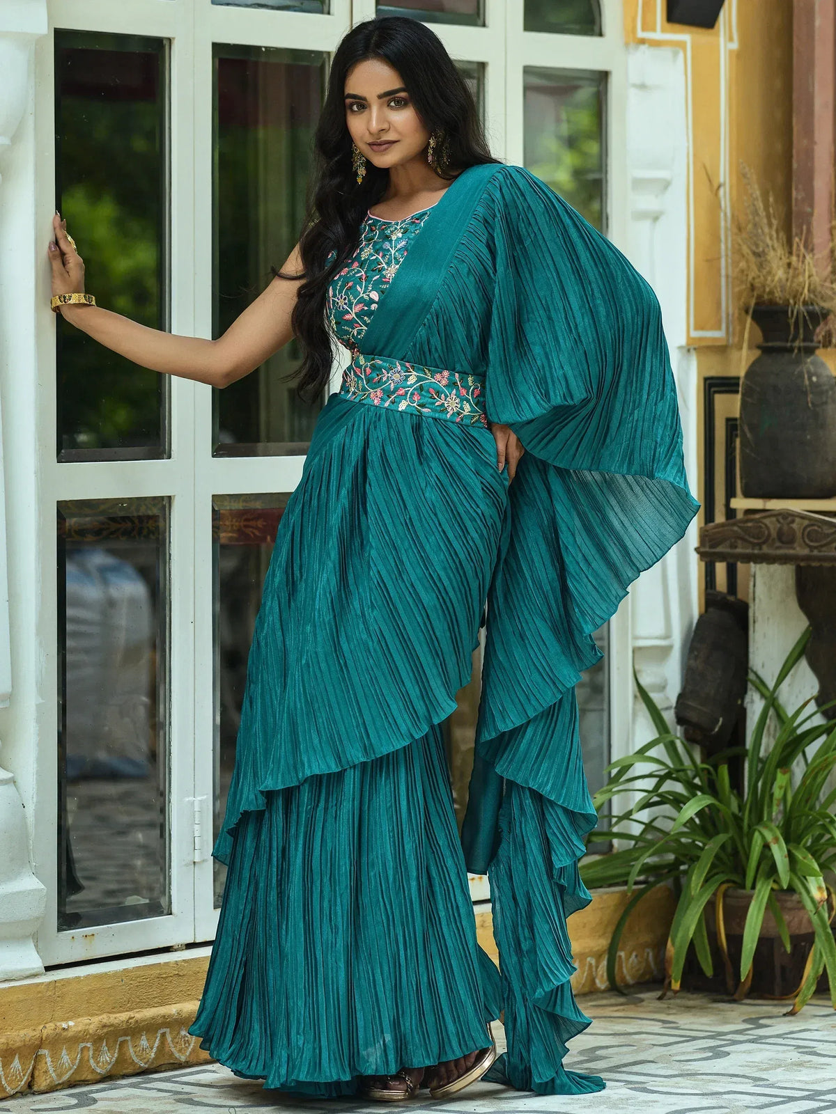 Teal pleated ethnic gown with floral embroidery, perfect for Indian occasions and festive wear.