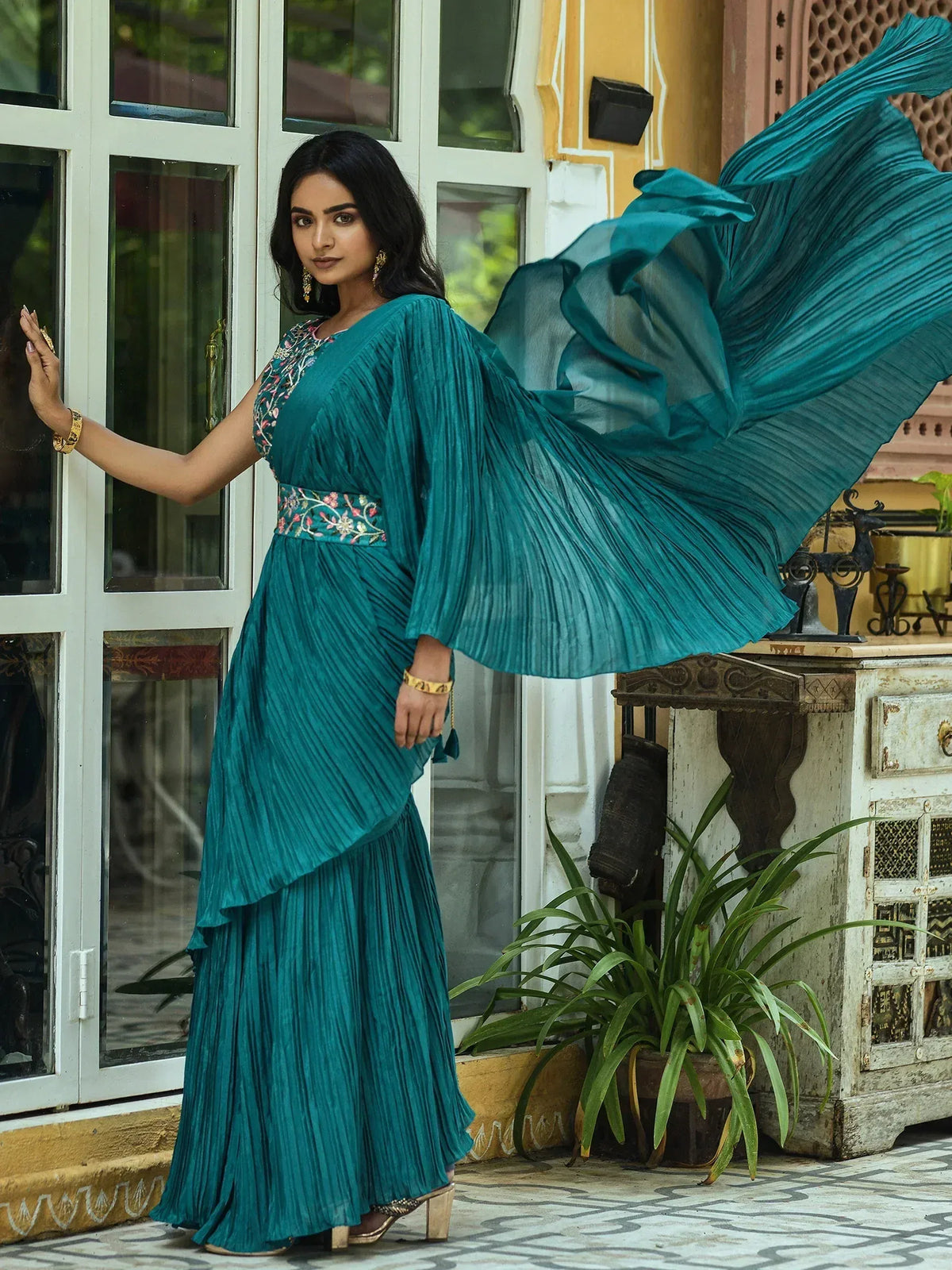 Teal pleated ethnic gown with floral embroidery, perfect for Indian occasions and festive wear.