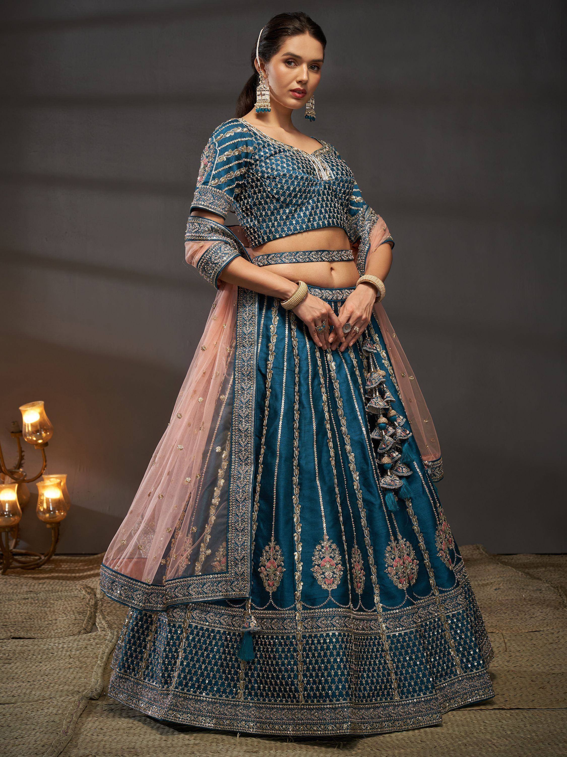Teal blue embroidered lehenga choli with pink dupatta, perfect for Indian weddings and festive occasions.
